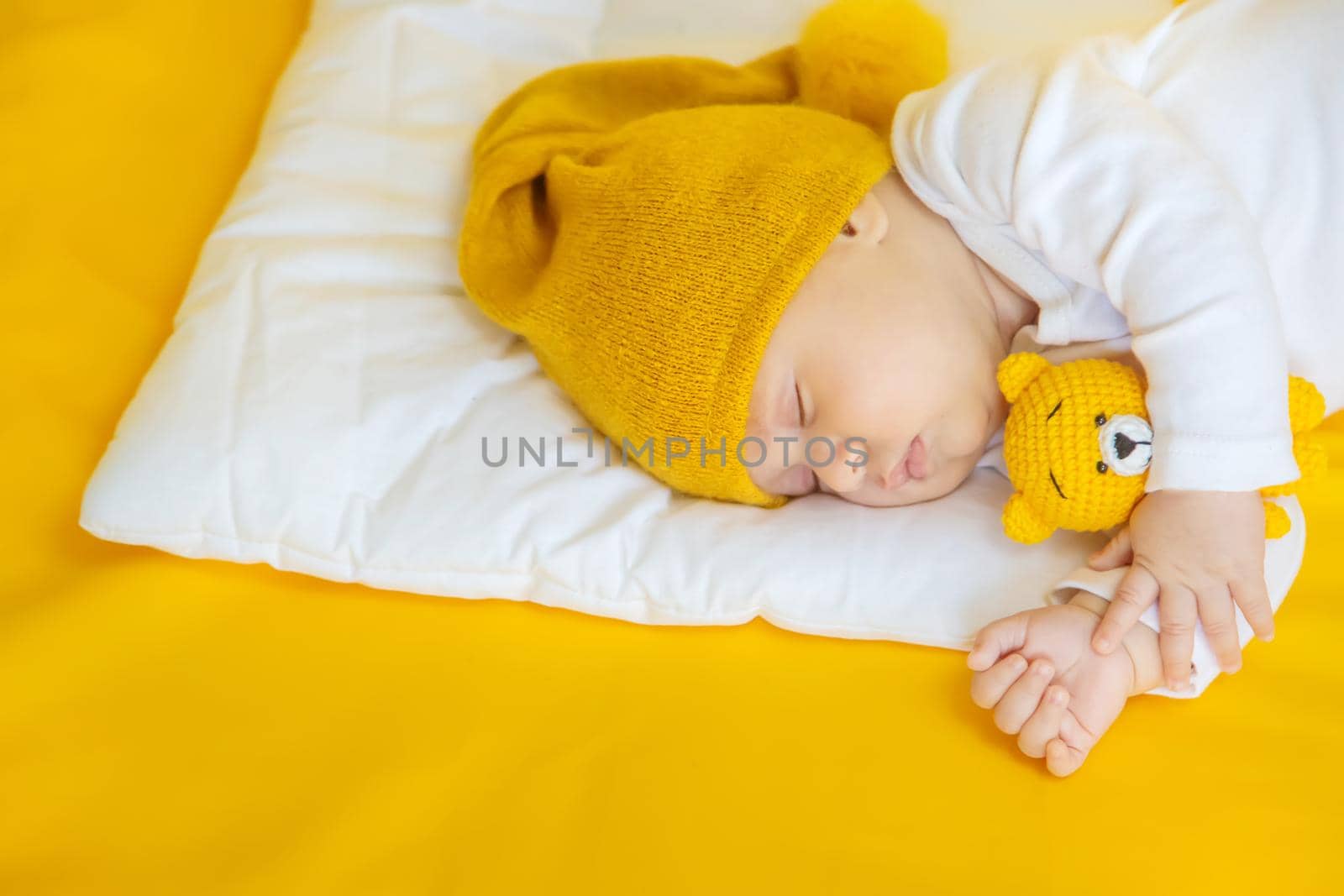Baby sleeps on a yellow background. Selective focus. People. Merry Christmas and Happy New Year, Holidays greeting card background. Selective focus.