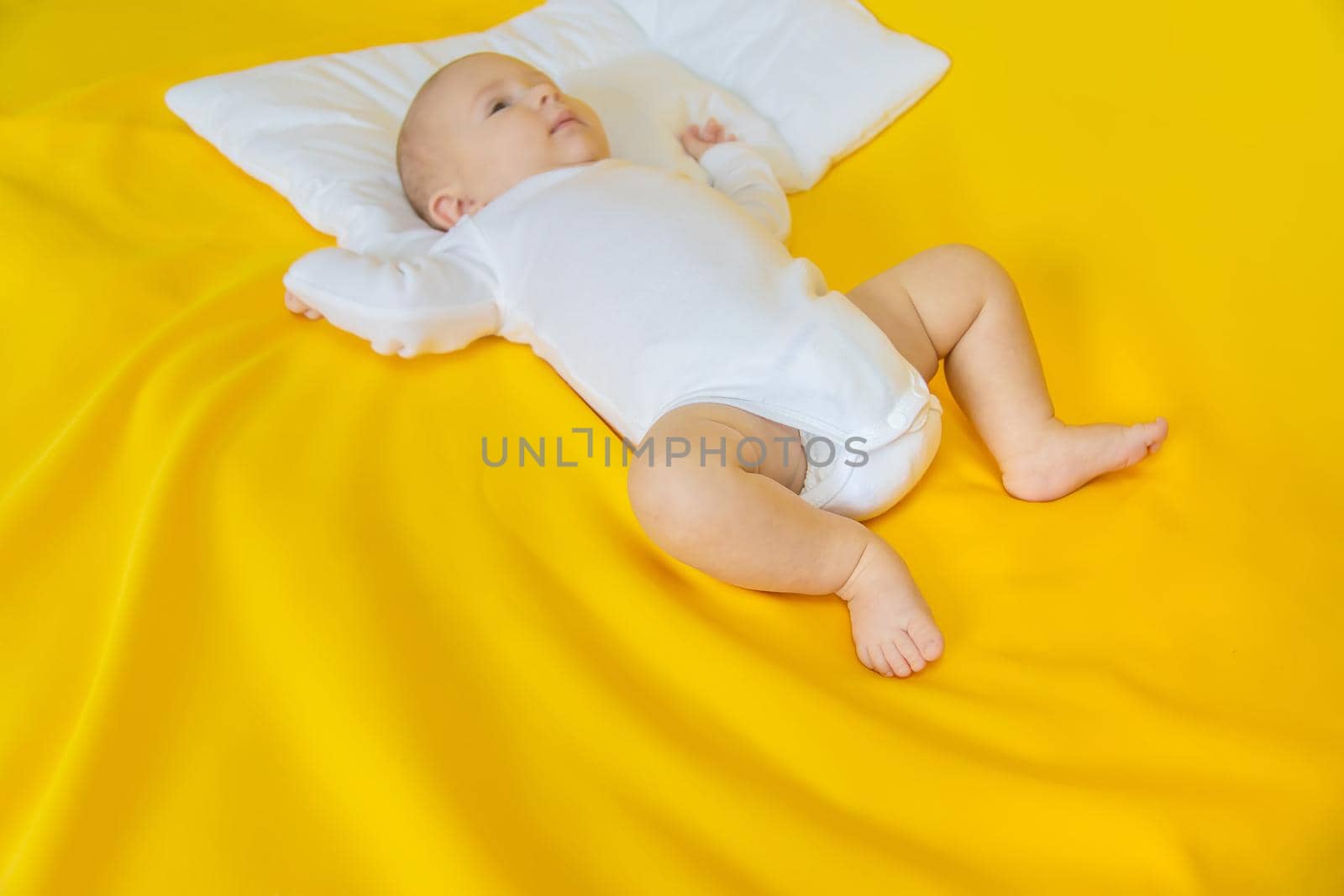Baby feet on a yellow background. Selective focus. People. Merry Christmas and Happy New Year, Holidays greeting card background. Selective focus.