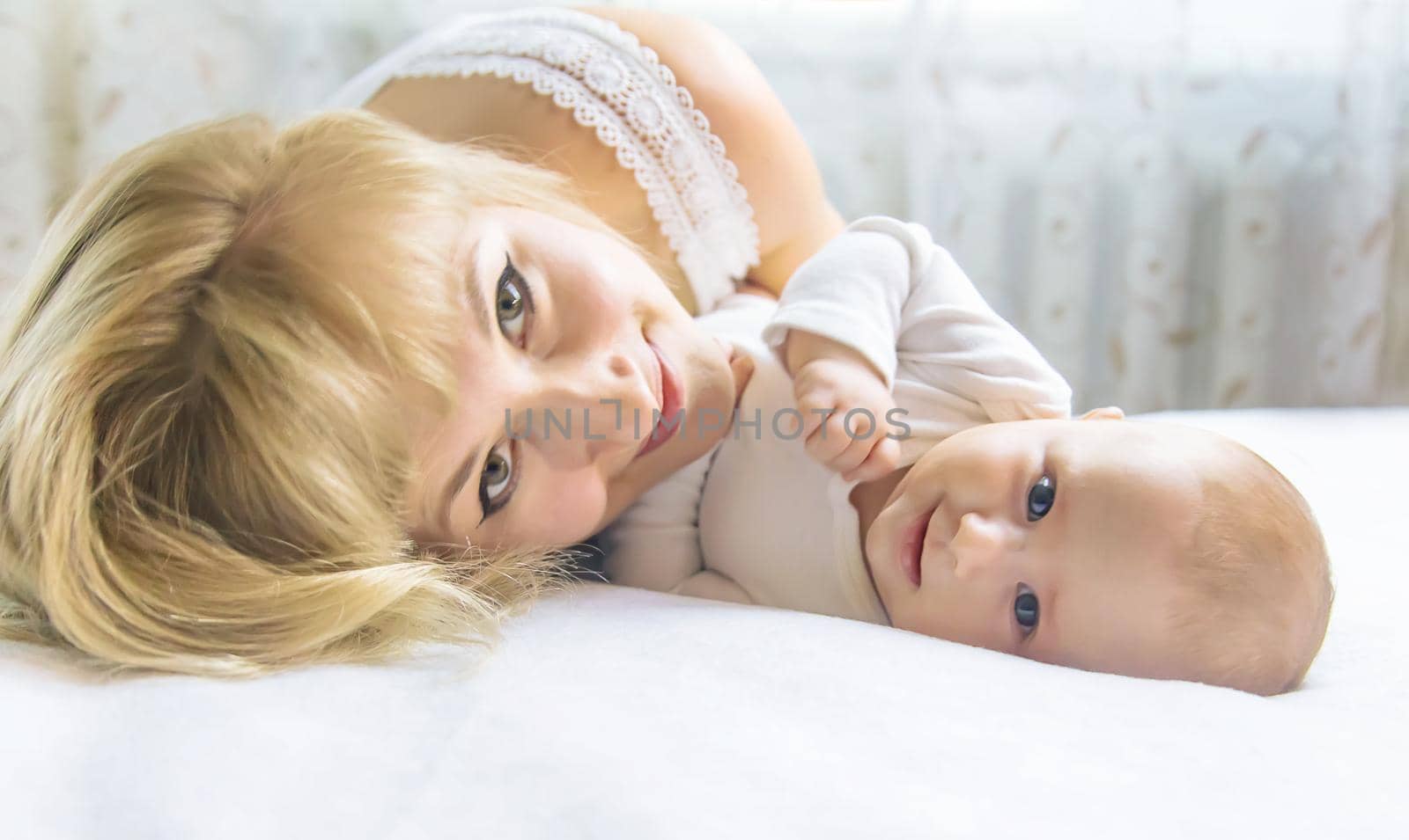 Mother with baby on a light background. Selective focus. People.