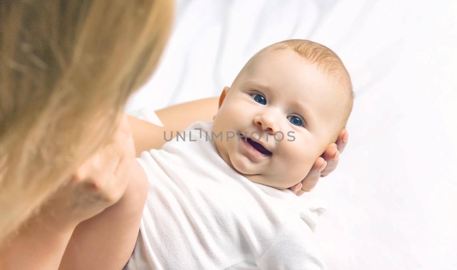 Mother with baby on a light background. Selective focus. People.