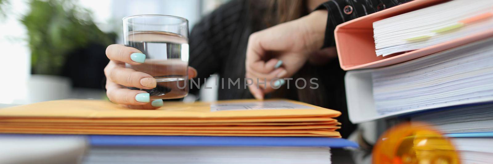 Close-up of tired woman clerk drink pill to stop headache because of big workload. Aspirin tablet on table to relief pain. Medicine, exhausted, job concept