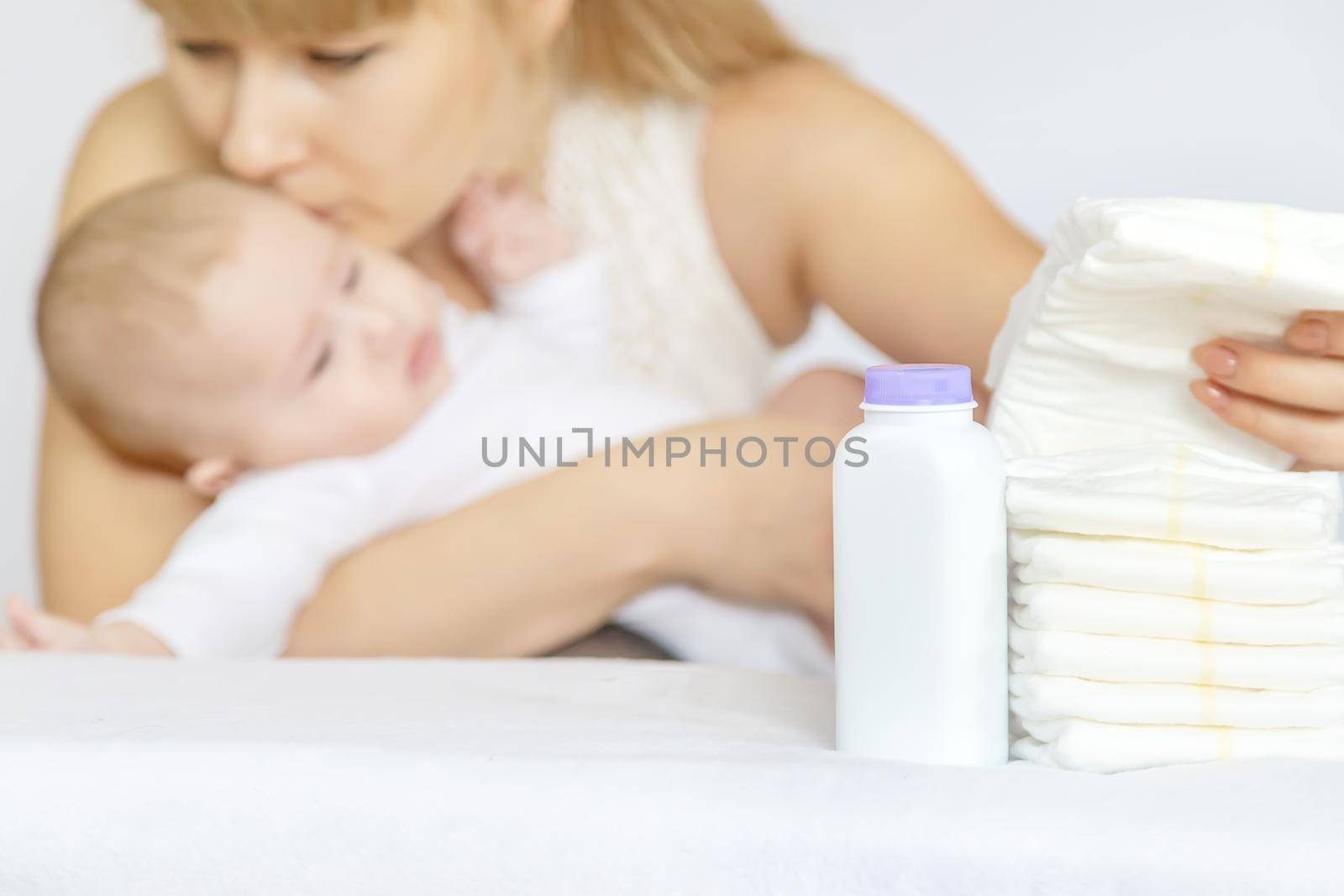 mother changes baby's diaper on a light background. Selective focus. people.