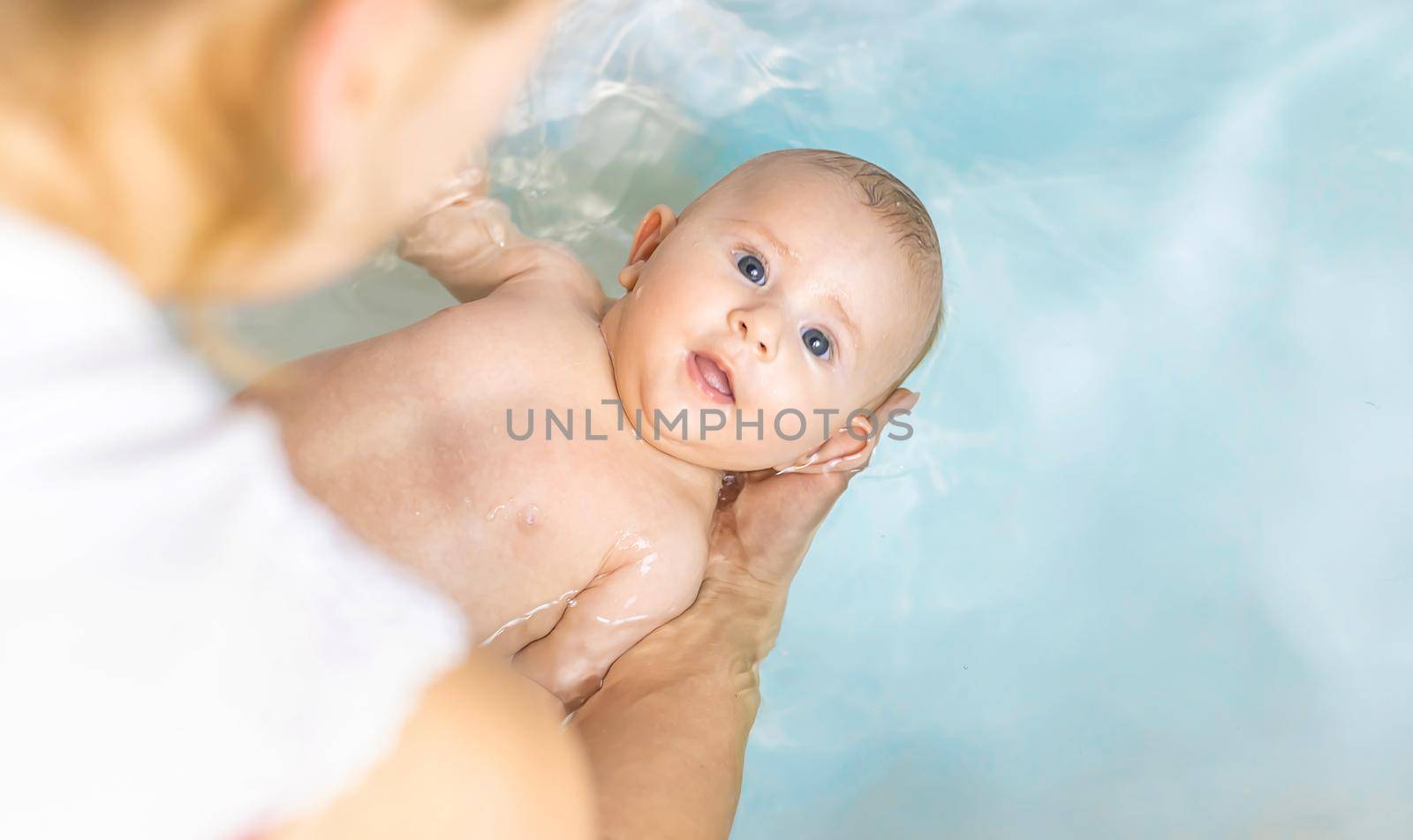 Baby after bathing in the bathroom. Selective focus. People.
