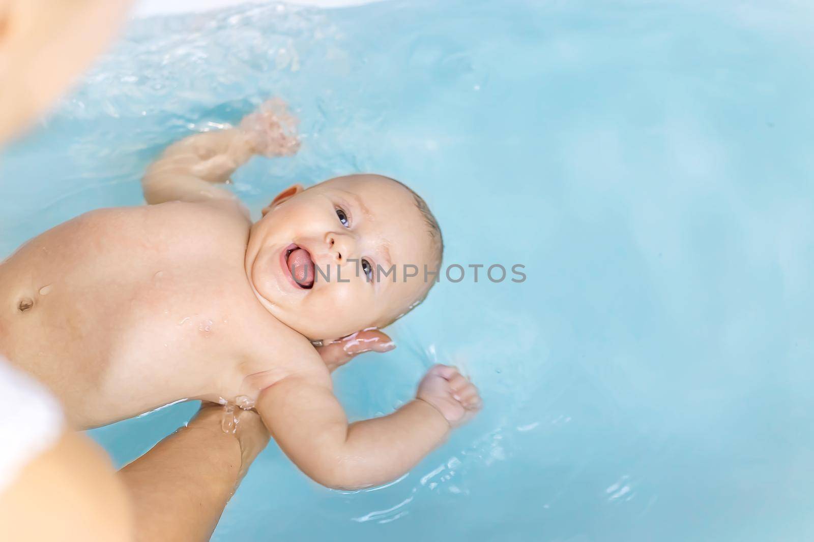 Baby after bathing in the bathroom. Selective focus. People.