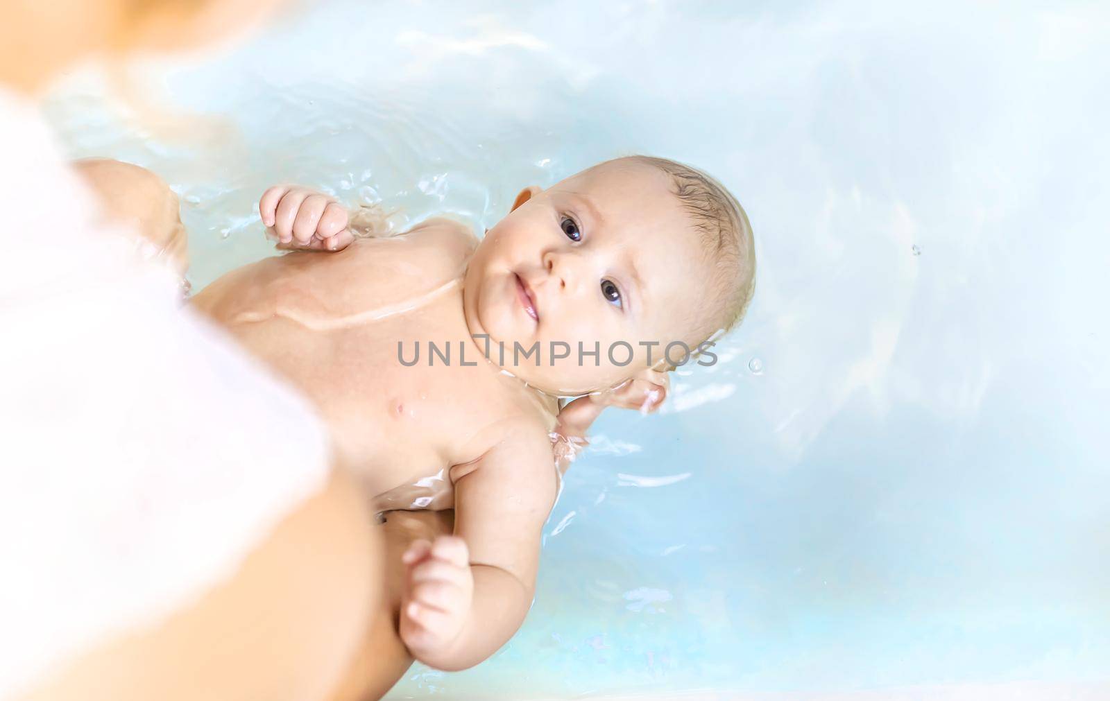 Baby after bathing in the bathroom. Selective focus. People.