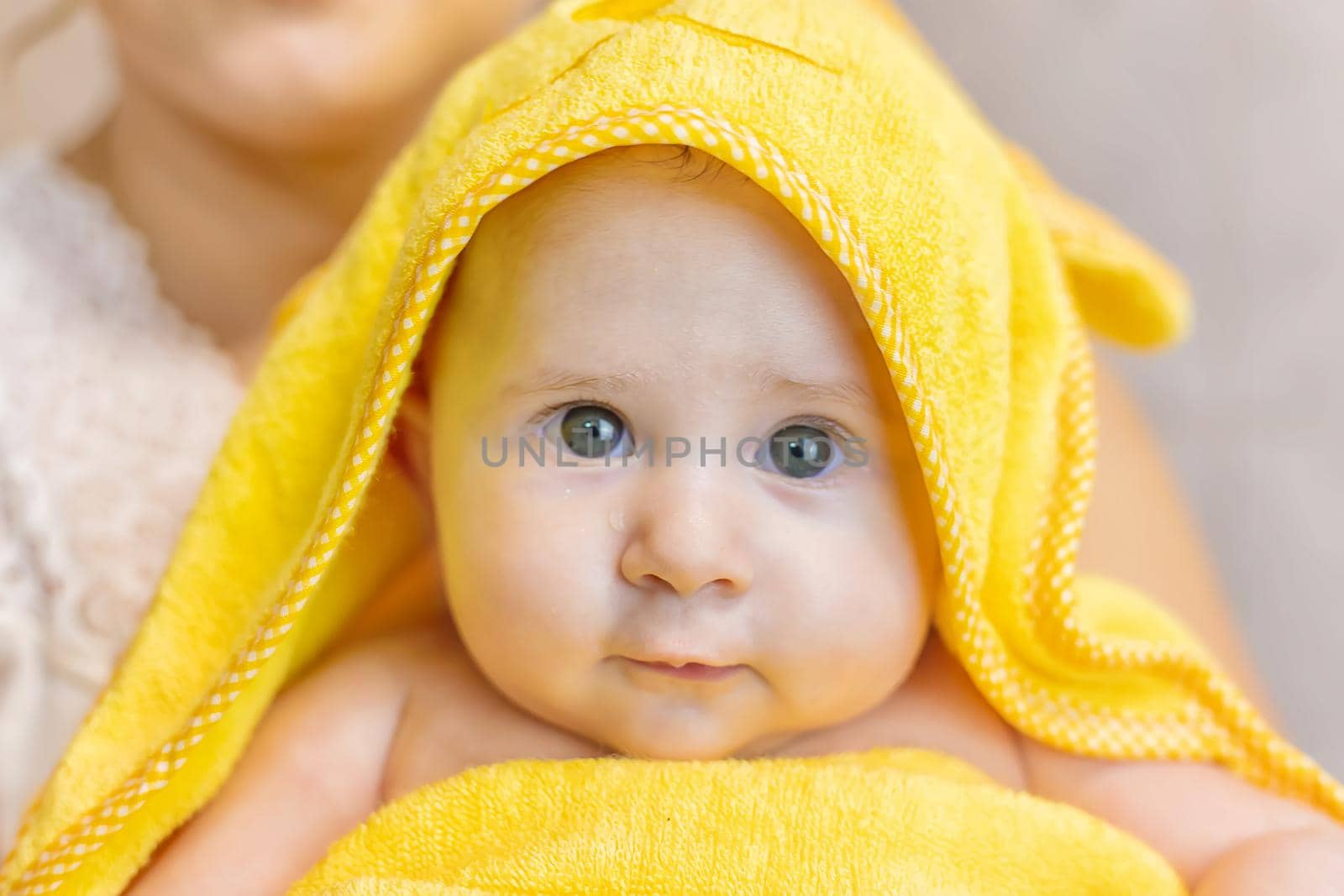 Baby after bathing in a towel. Selective focus. People.