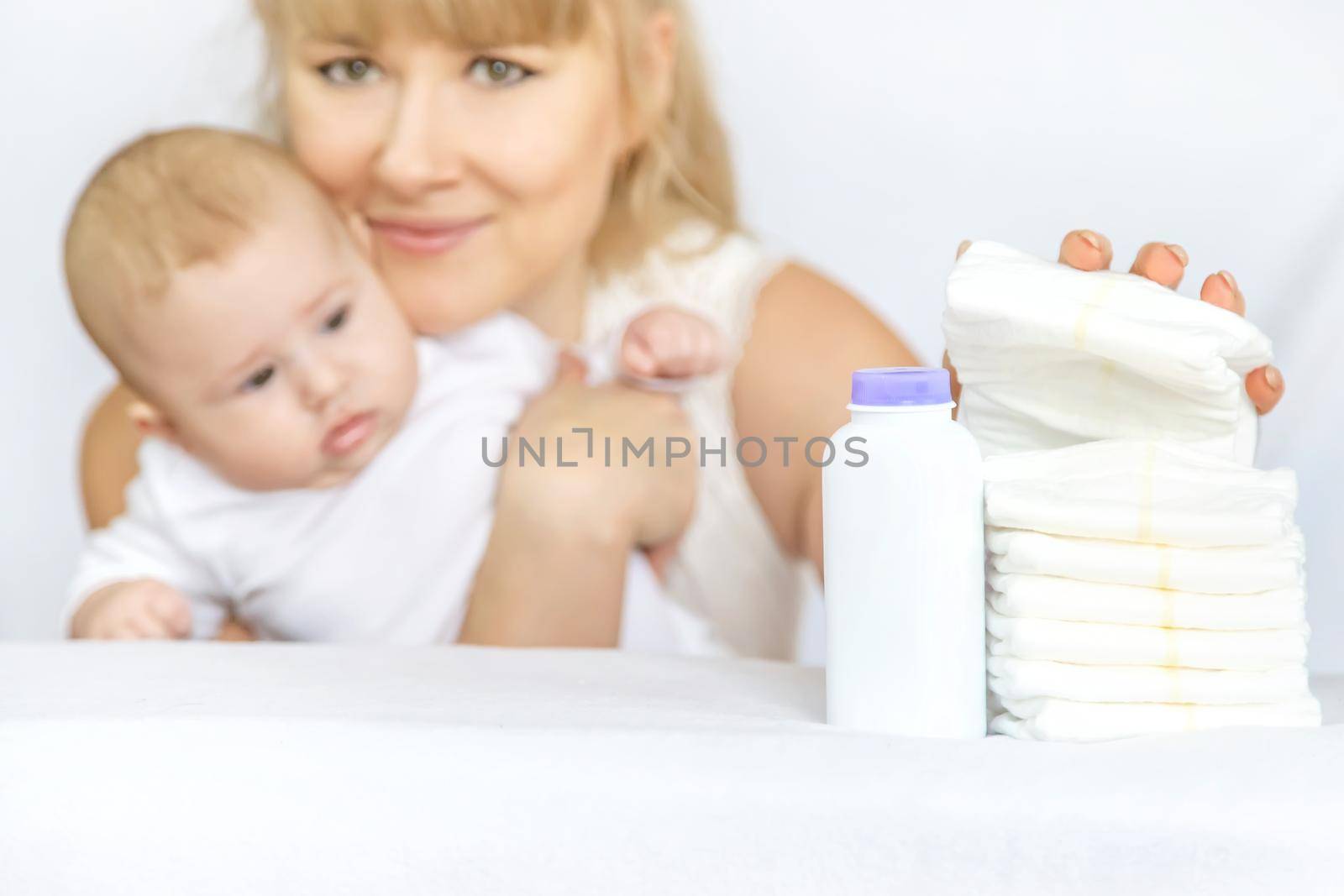 mother changes baby's diaper on a light background. Selective focus. people.