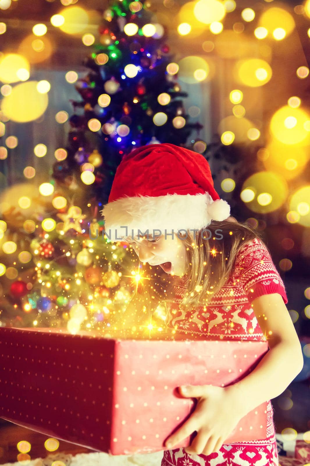 Child opens gifts under the Christmas tree. Selective focus. by yanadjana