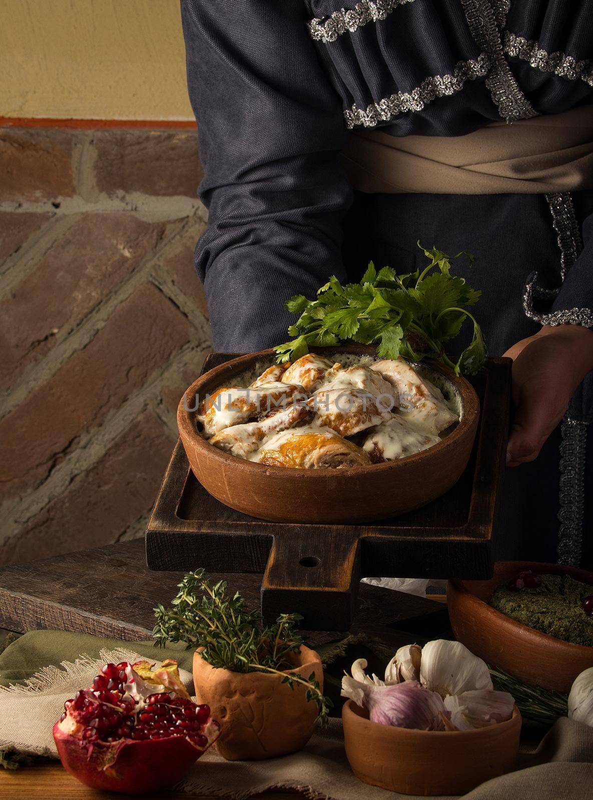 A vertical shot of a waitress presenting a chicken covered in a creamy sauce