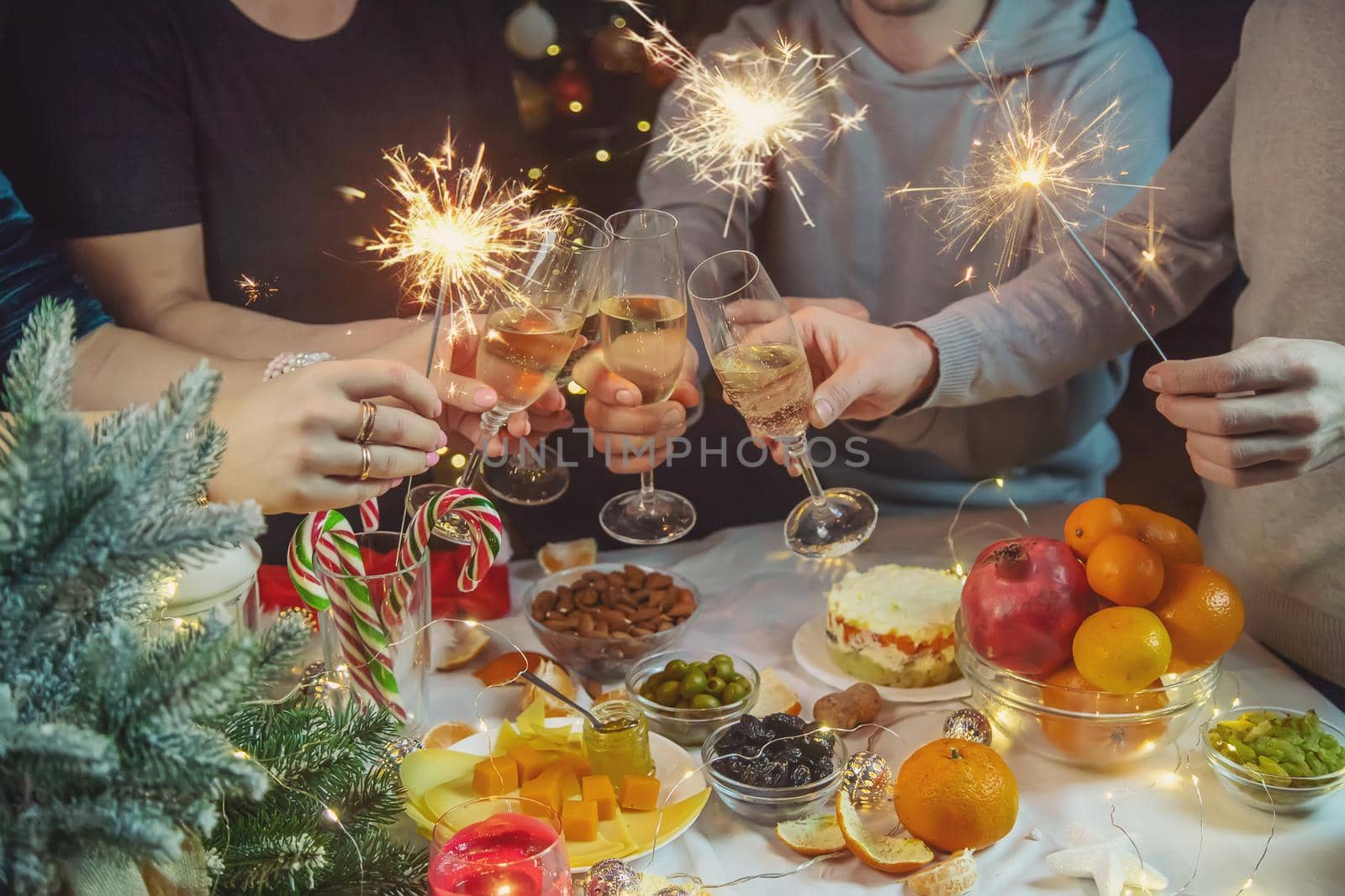 Champagne in hand against the background of the Christmas tree. People. Selective focus. Holiday.