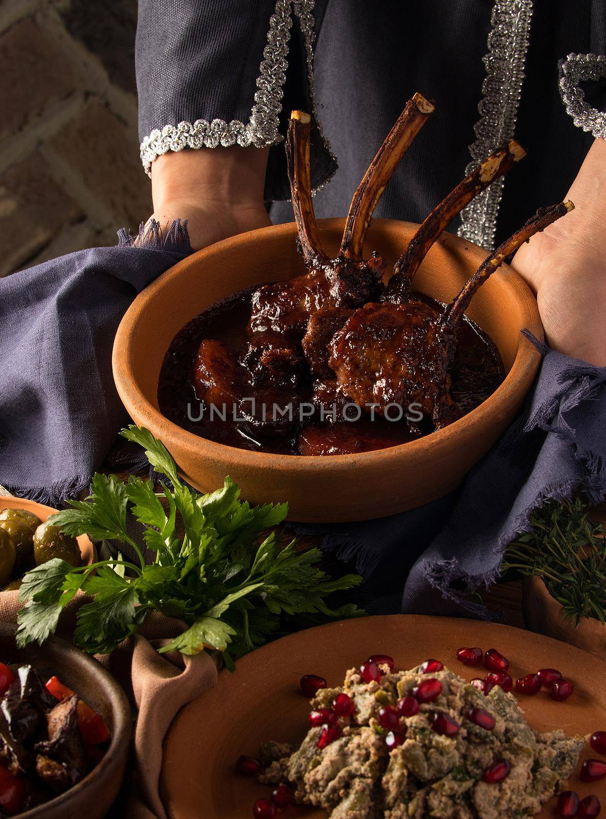 A vertical shot of a waitress presenting a tomahawk steak