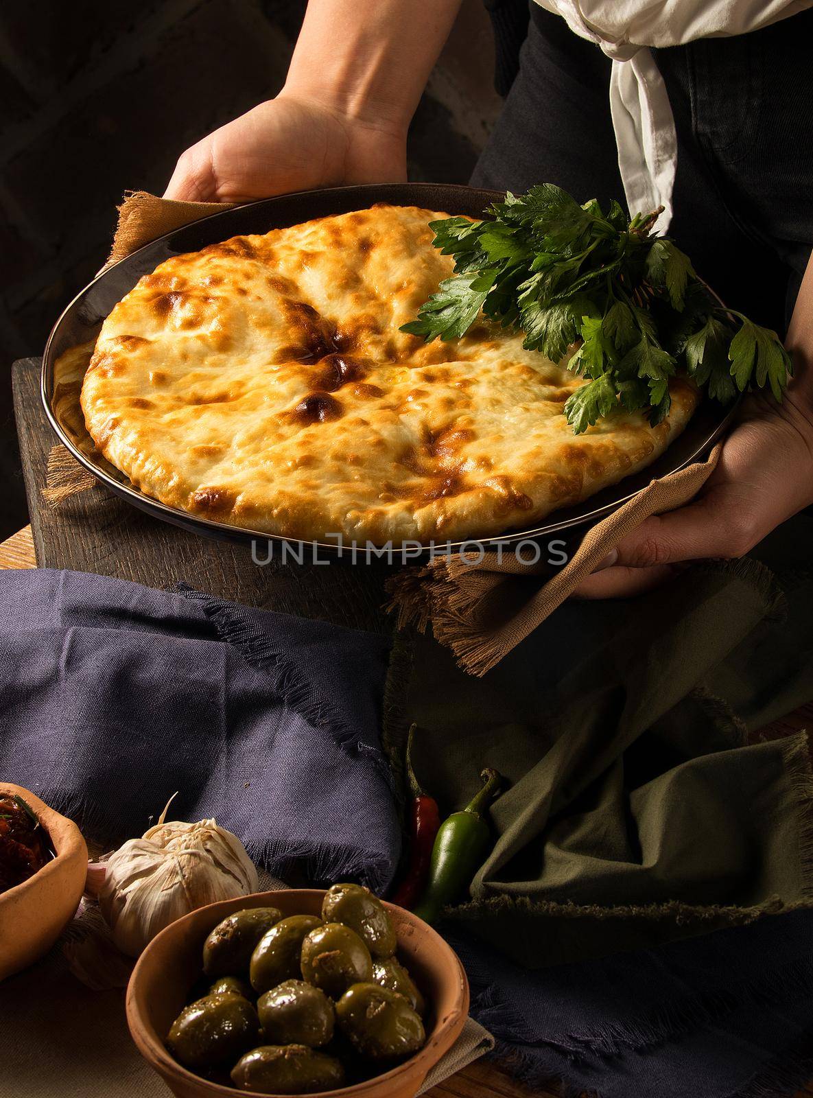 A vertical shot of a chef serving a gourmet Georgian dish