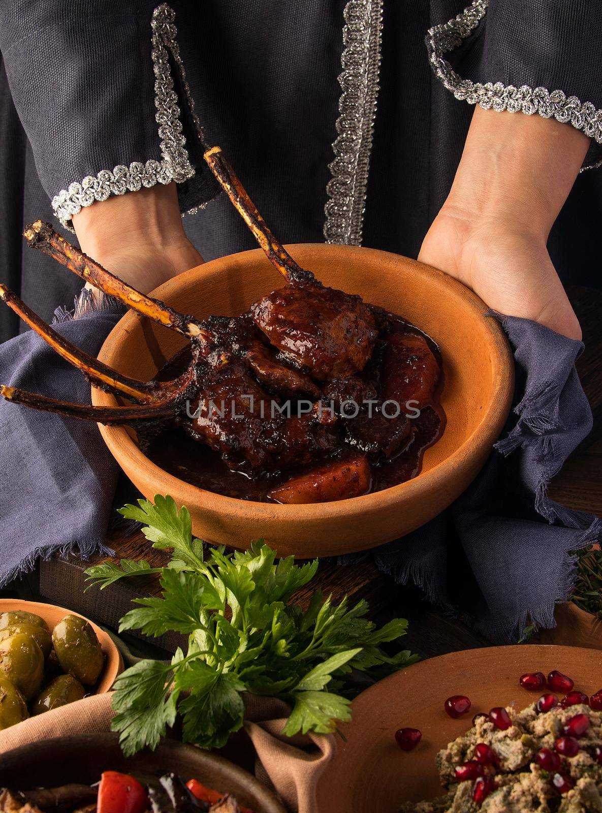 A vertical shot of a waitress presenting a tomahawk steak