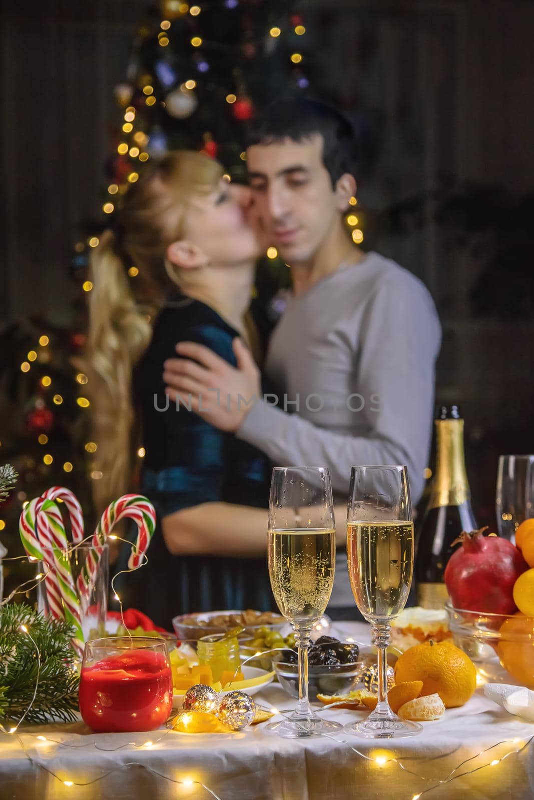 Champagne in hand against the background of the Christmas tree. People. Selective focus. Holiday.