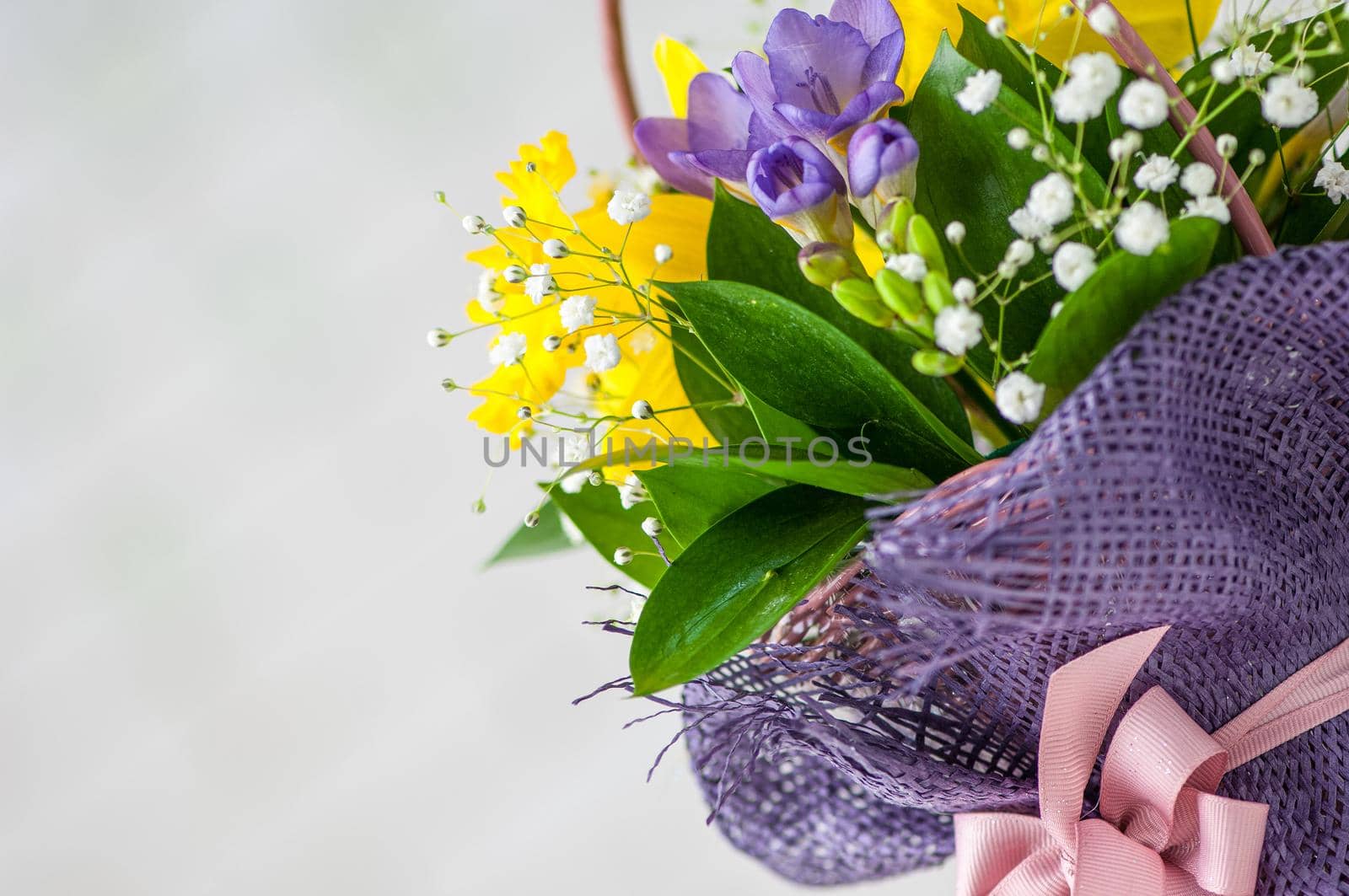 A closeup of a beautiful bouquet with purple freesia and daffodils isolated on a white background