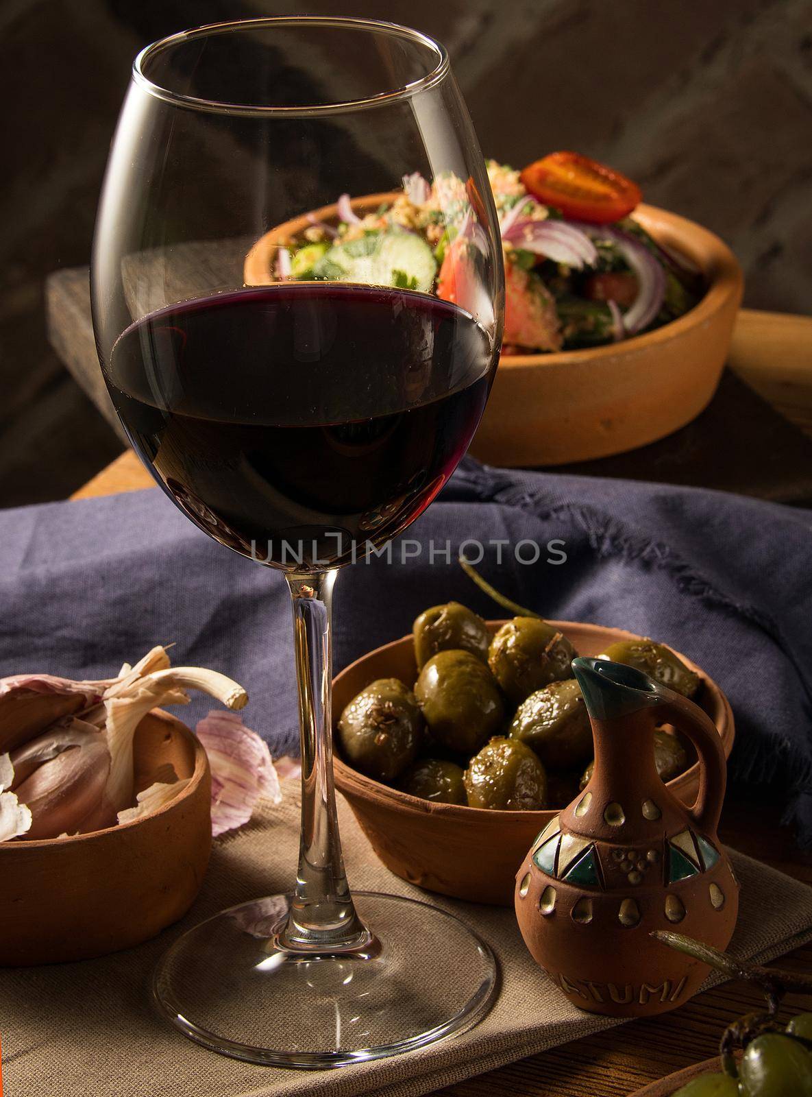 A glass of wine on a table with dishes