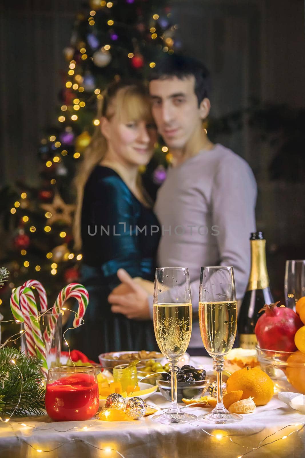 Champagne in hand against the background of the Christmas tree. People. Selective focus. Holiday.