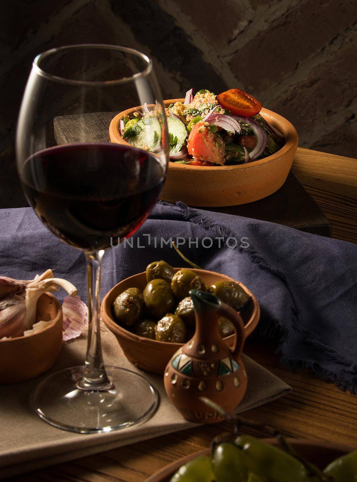 A glass of wine on a table with dishes
