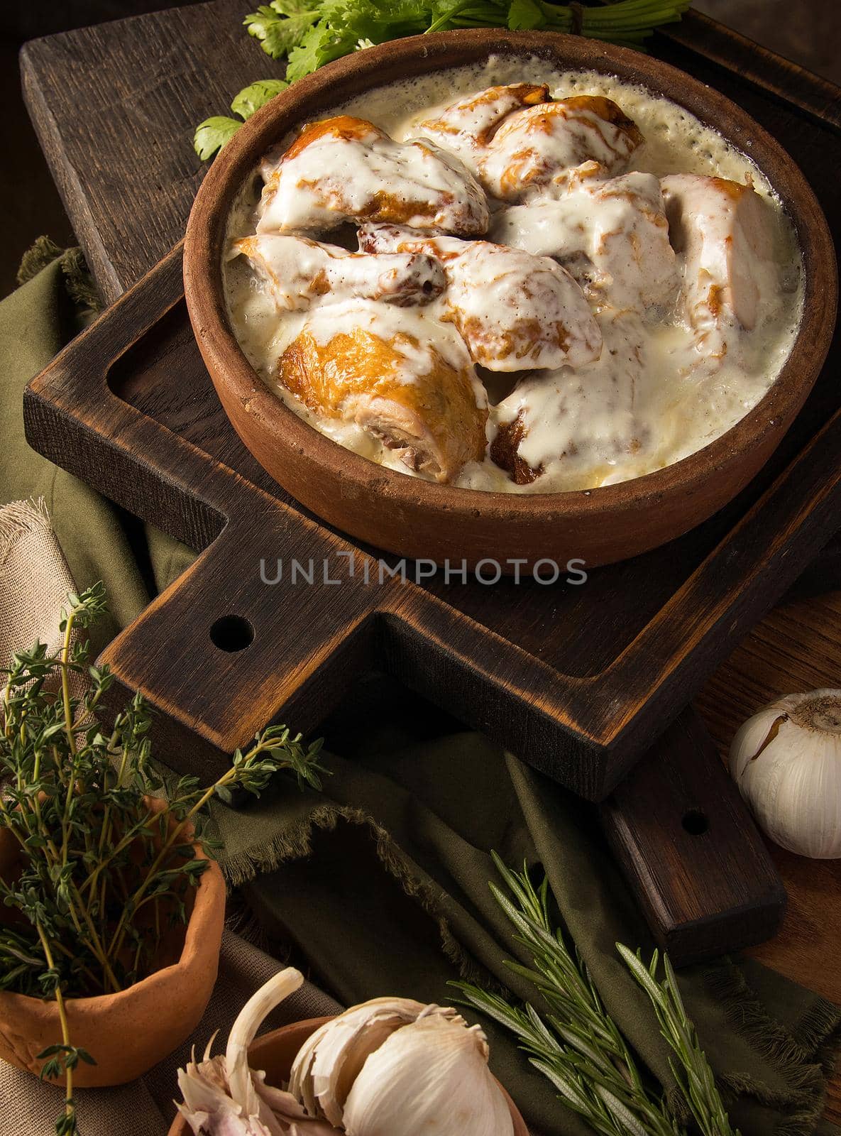 A vertical shot of a chicken covered in a creamy sauce