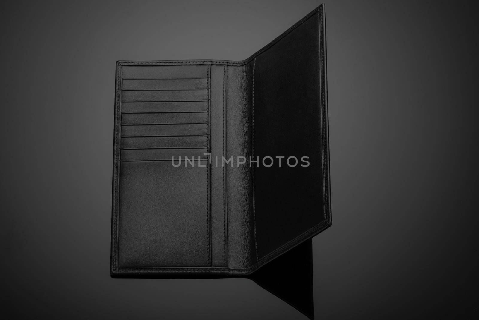 A closeup of a fashionable leather men's wallet on a dark background