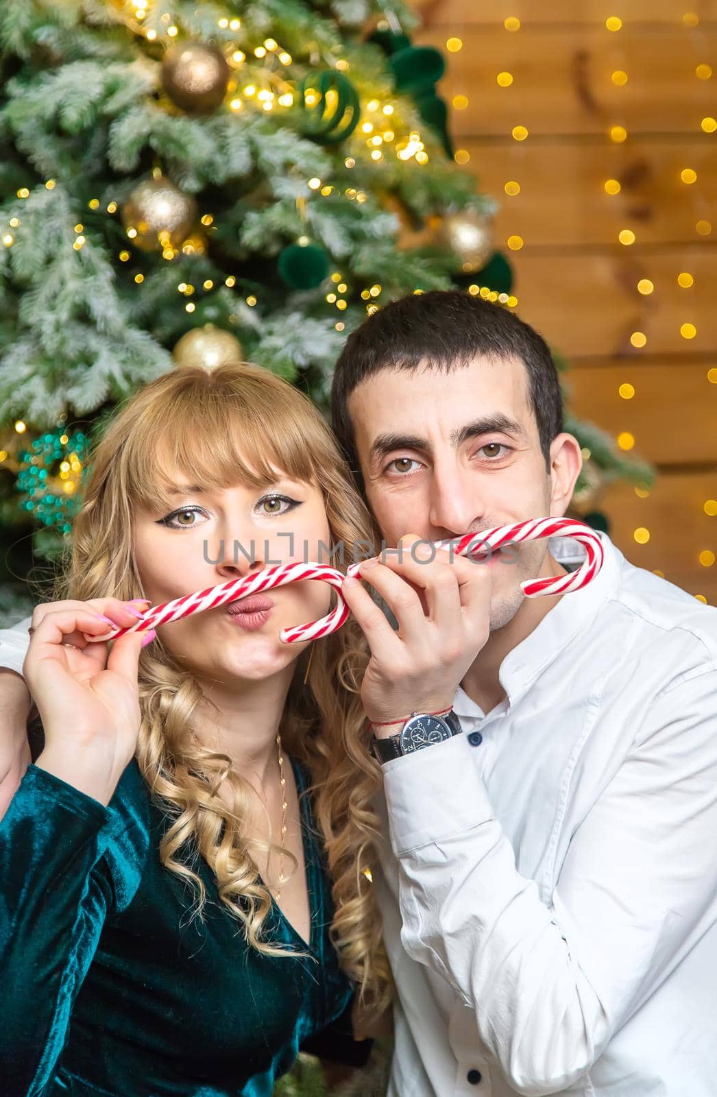 Christmas lollipops in the hands of a man and a woman. Selective focus. Holiday.