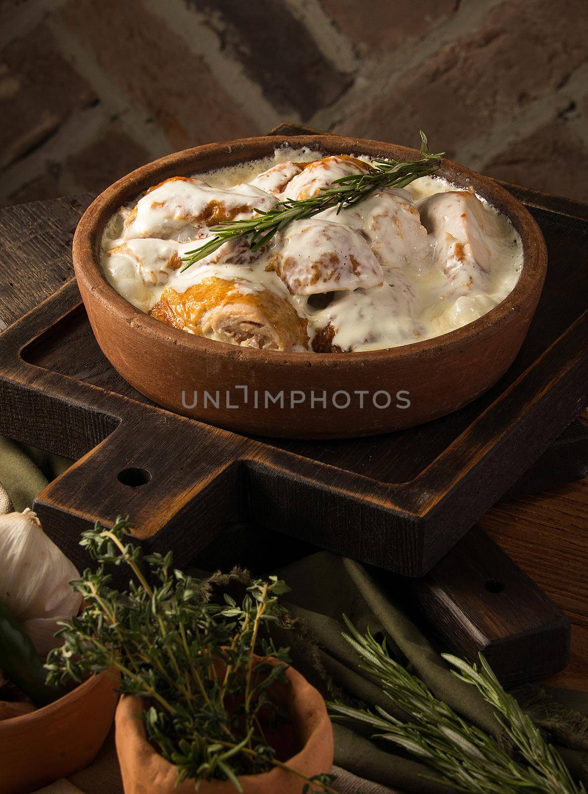 A vertical shot of a chicken covered in a creamy sauce