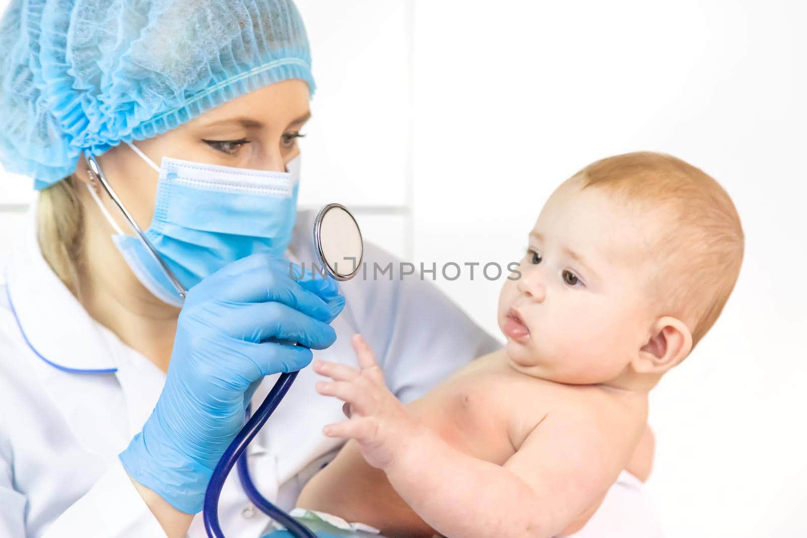 The doctor listens to the baby with a stethoscope. Selective focus. People.