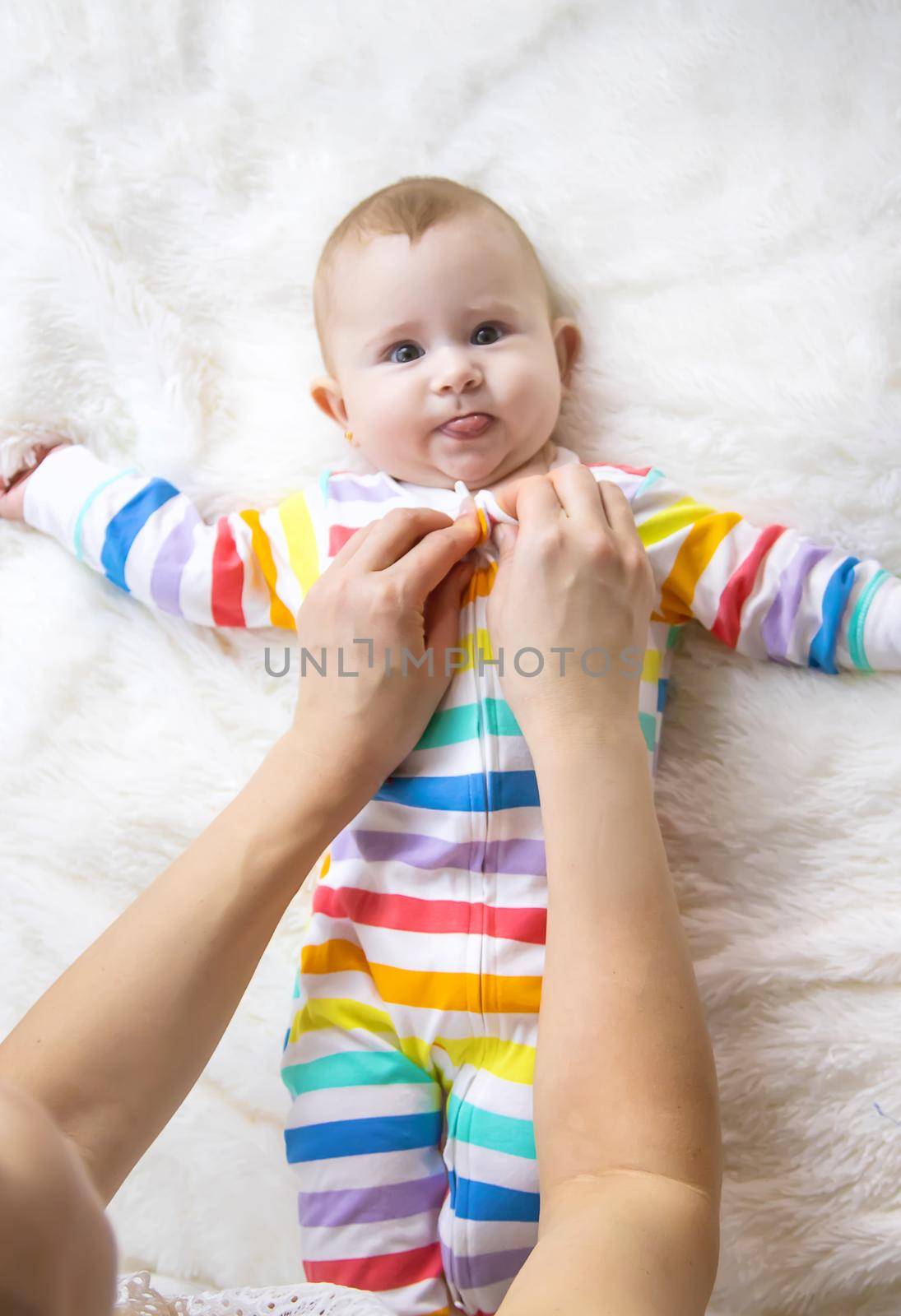 mother dresses her little baby. Selective focus. child.