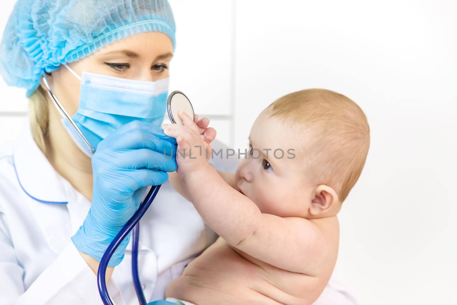 The doctor listens to the baby with a stethoscope. Selective focus. People.