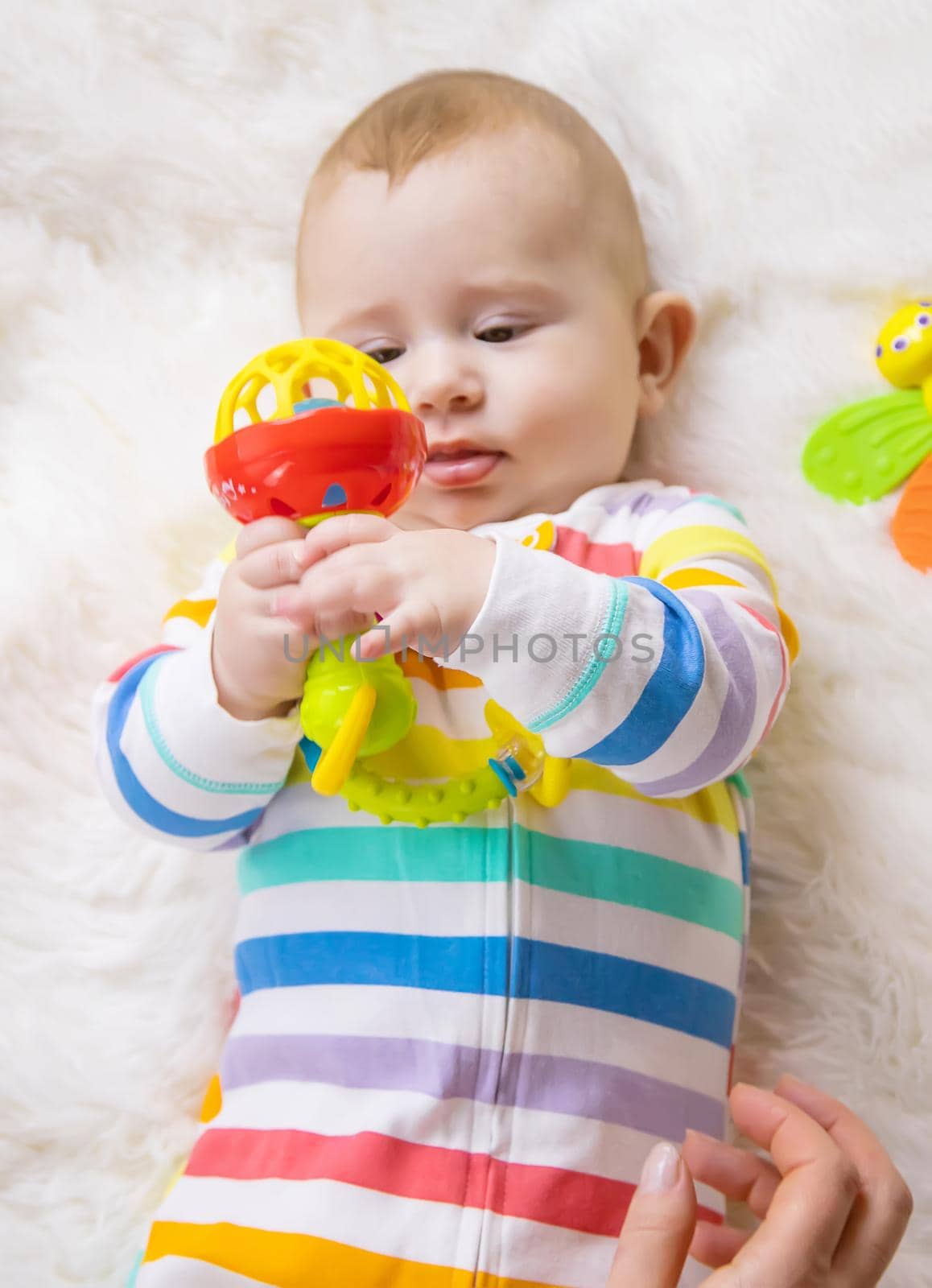 The mother gives a rattle to the baby. Selective focus. child.