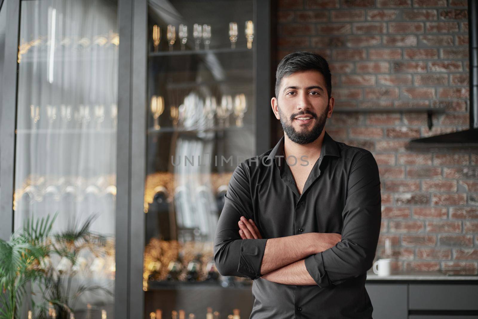 portrait of a business owner standing in his wine shop.