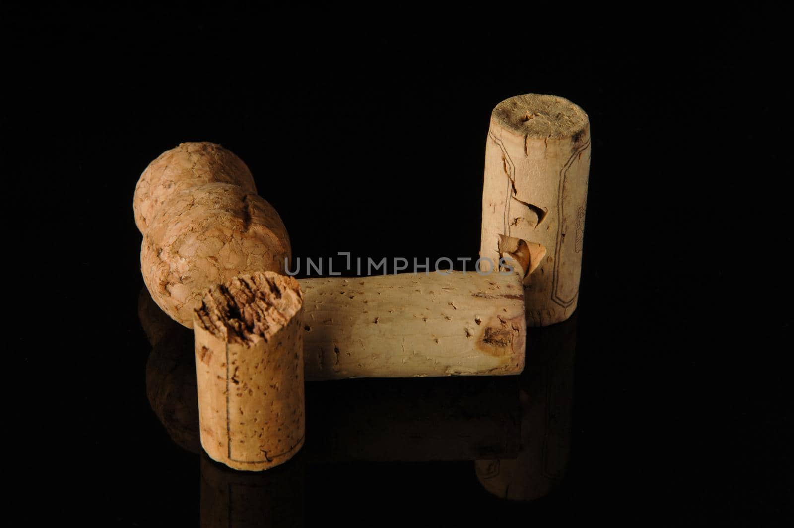 A close-up shot of some wine corks on a reflecting surface.