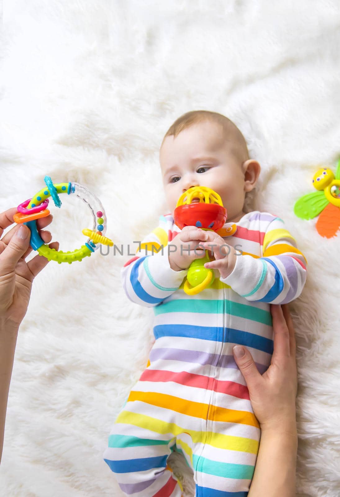 The mother gives a rattle to the baby. Selective focus. child.