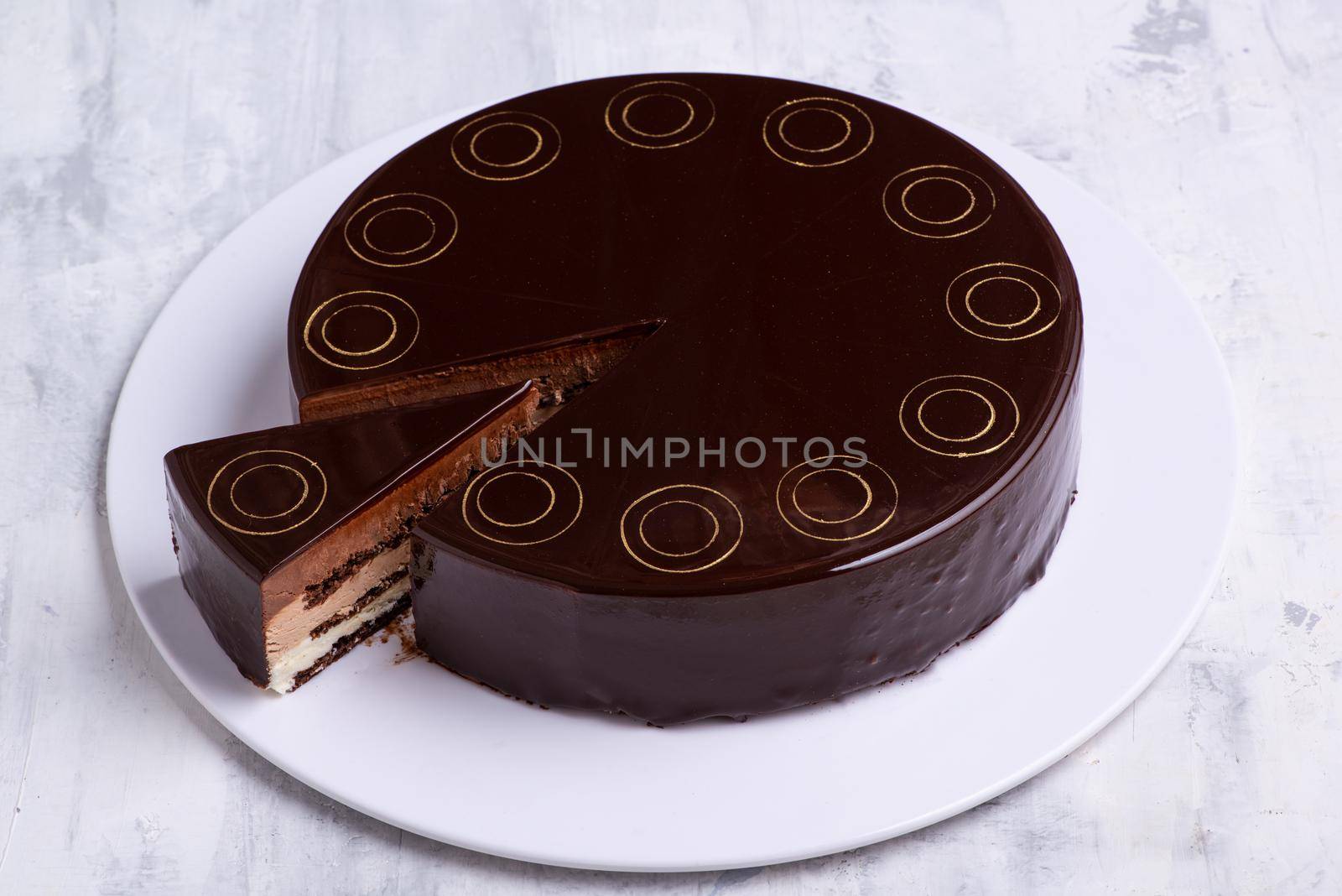 A top view shot of a chocolate cake on a white plate