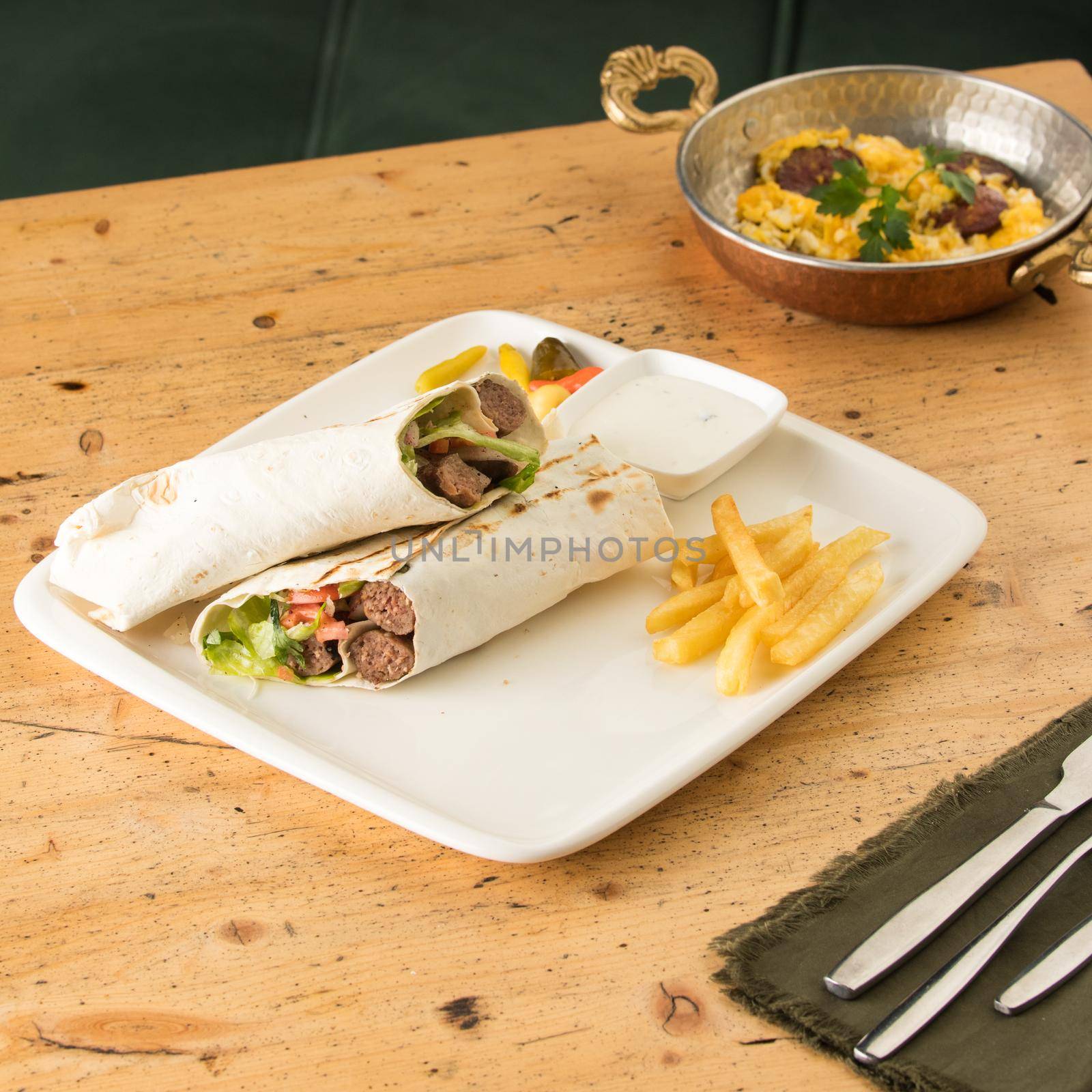 Closeup shot of kebabs with vegetables wrapped in a tortilla by A_Karim