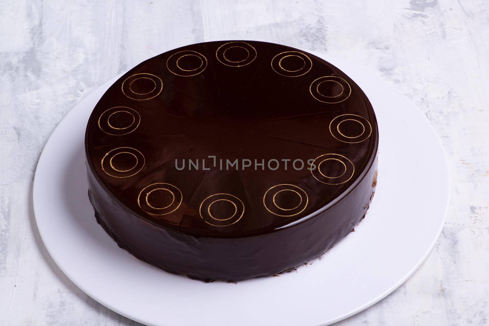 A top view shot of a chocolate cake on a white plate