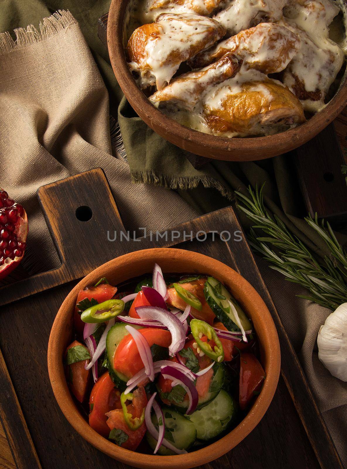 A vertical shot of a chicken covered in creamy sauce and eggplant salad