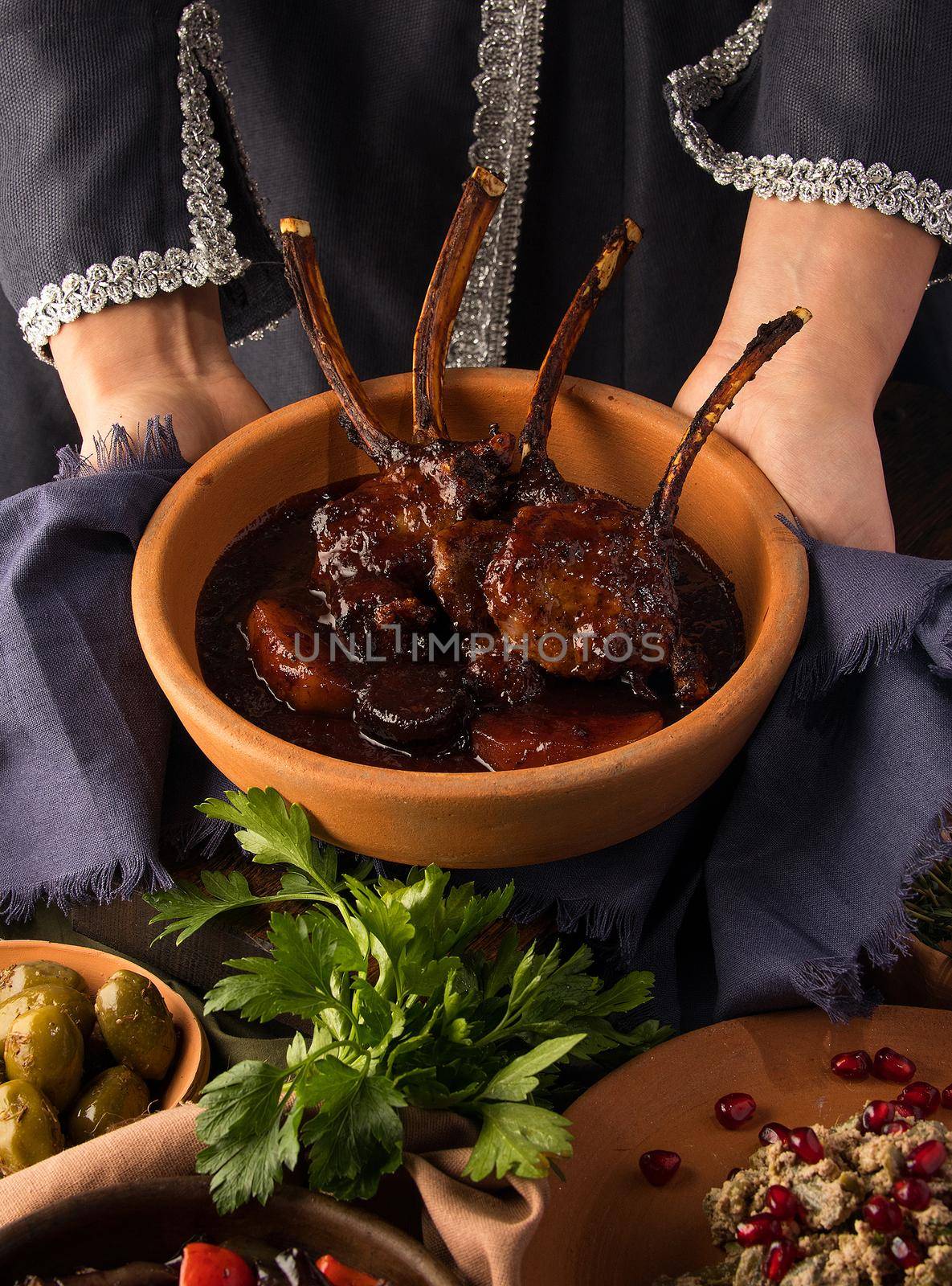 A vertical shot of a waitress presenting a tomahawk steak