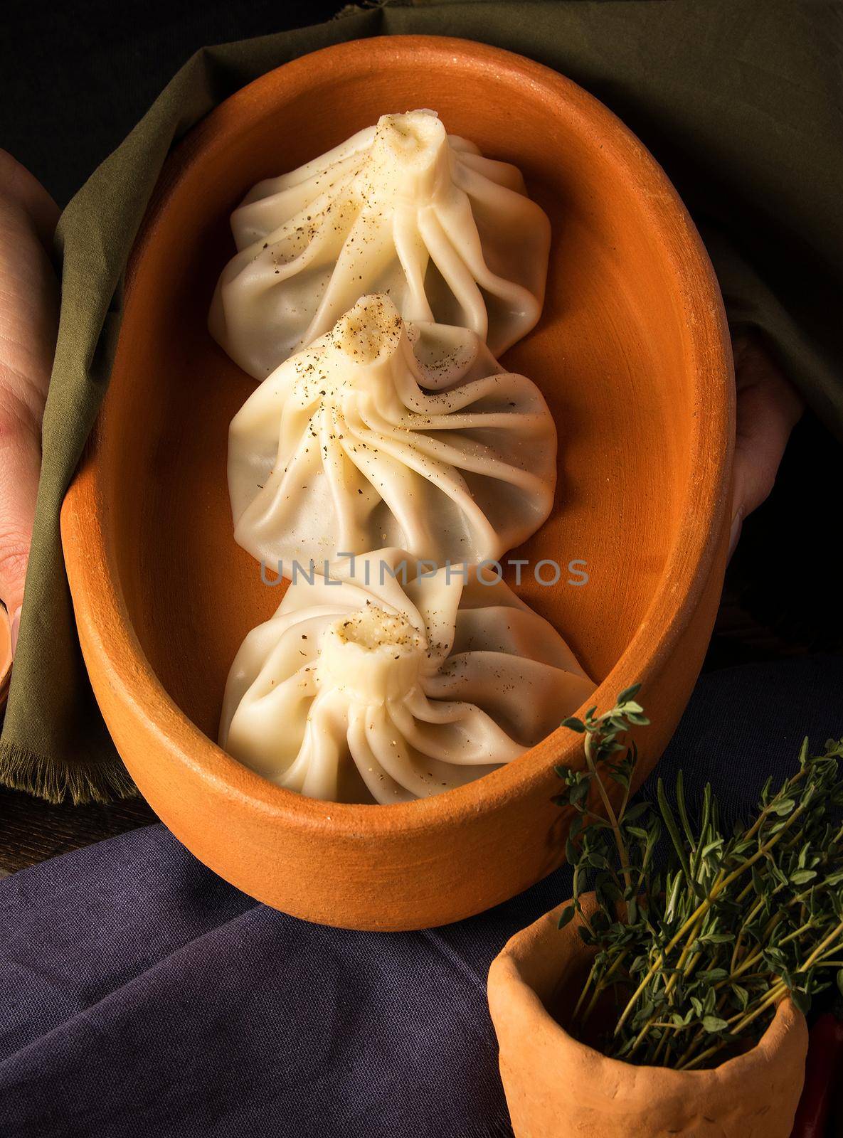 A vertical shot of a luxurious restaurant table with a gourmet khinkali dish