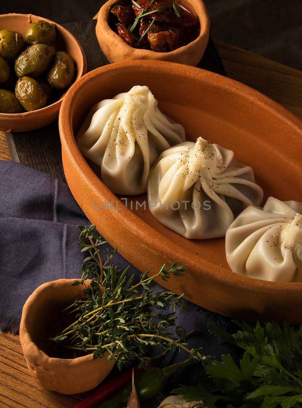 Vertical shot of a luxurious restaurant table with a gourmet khinkali dish by A_Karim