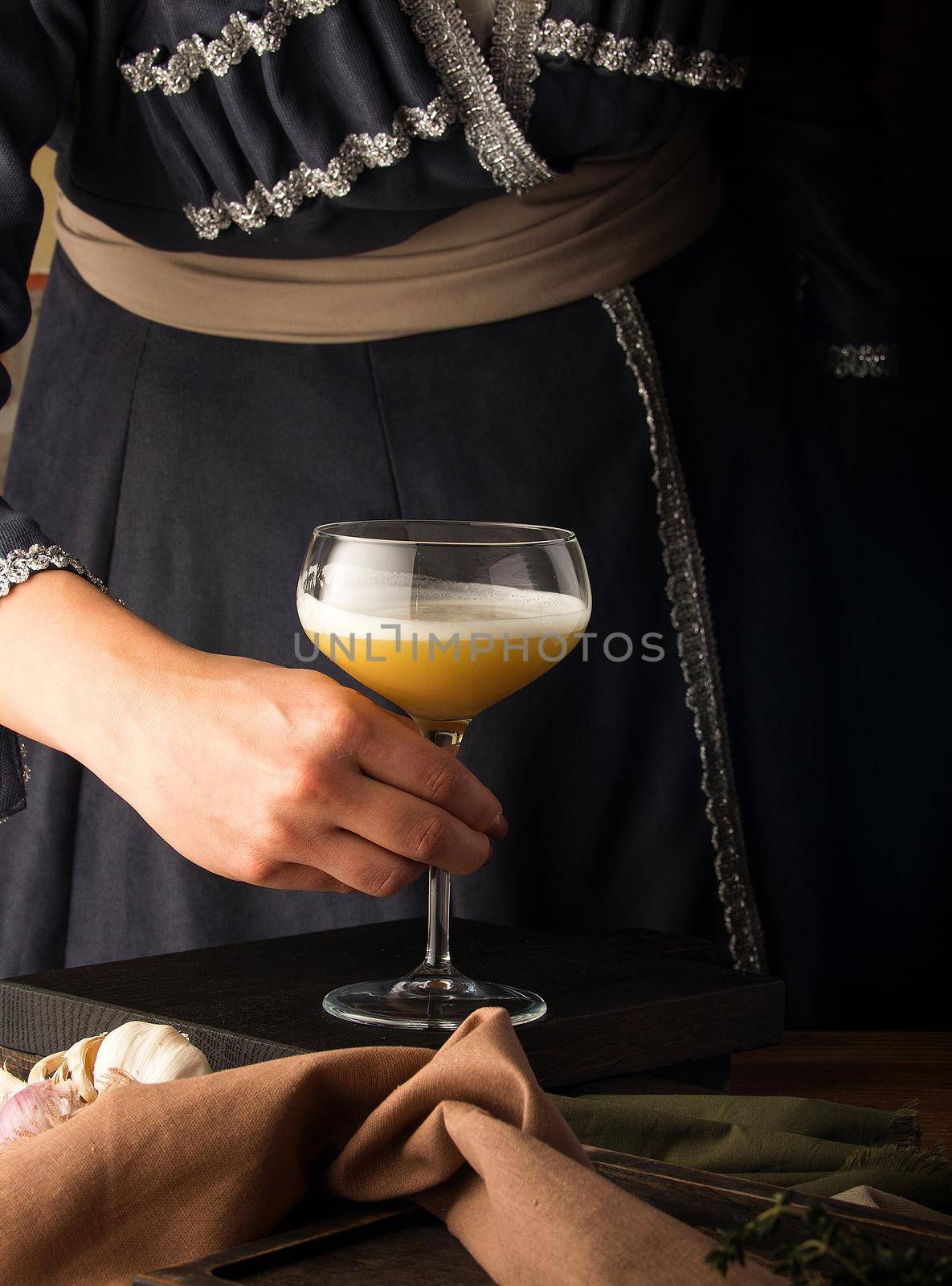 A vertical shot of a waitress presenting a cocktail