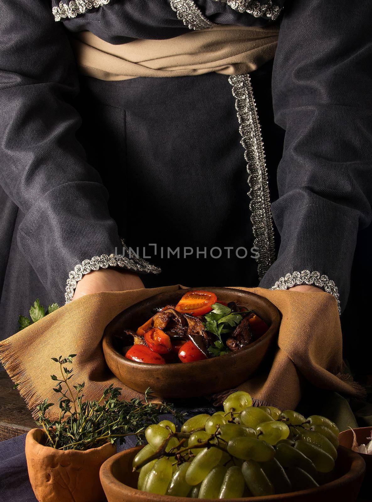 A vertical shot of a chef serving a gourmet salad dish