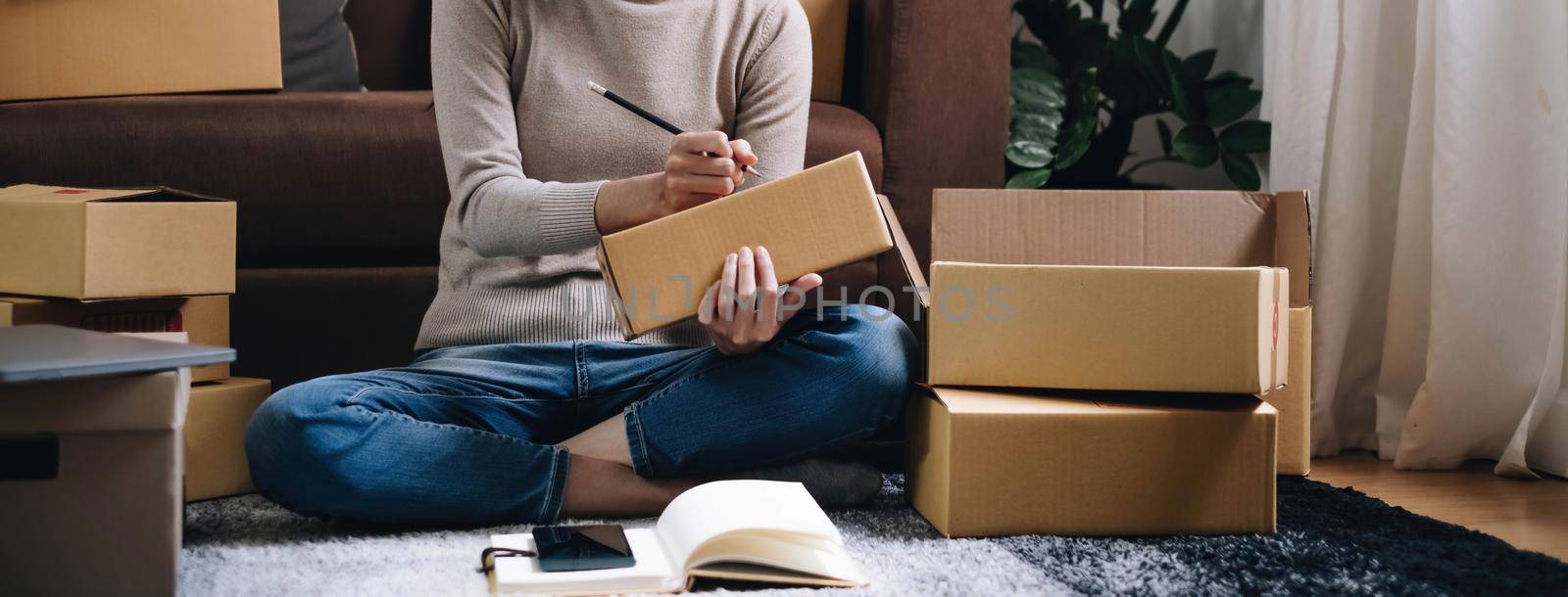 Starting small businesses SME owners female entrepreneurs Write the address on receipt box and check online orders to prepare to pack the boxes, sell to customers, sme business ideas online. by wichayada