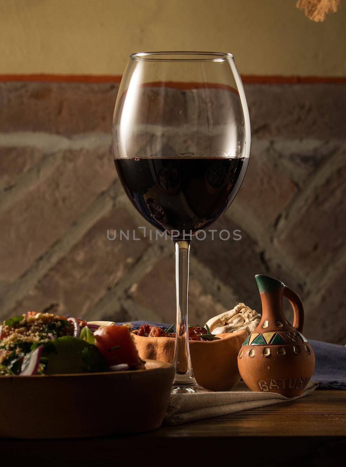 A glass of wine on a table with dishes