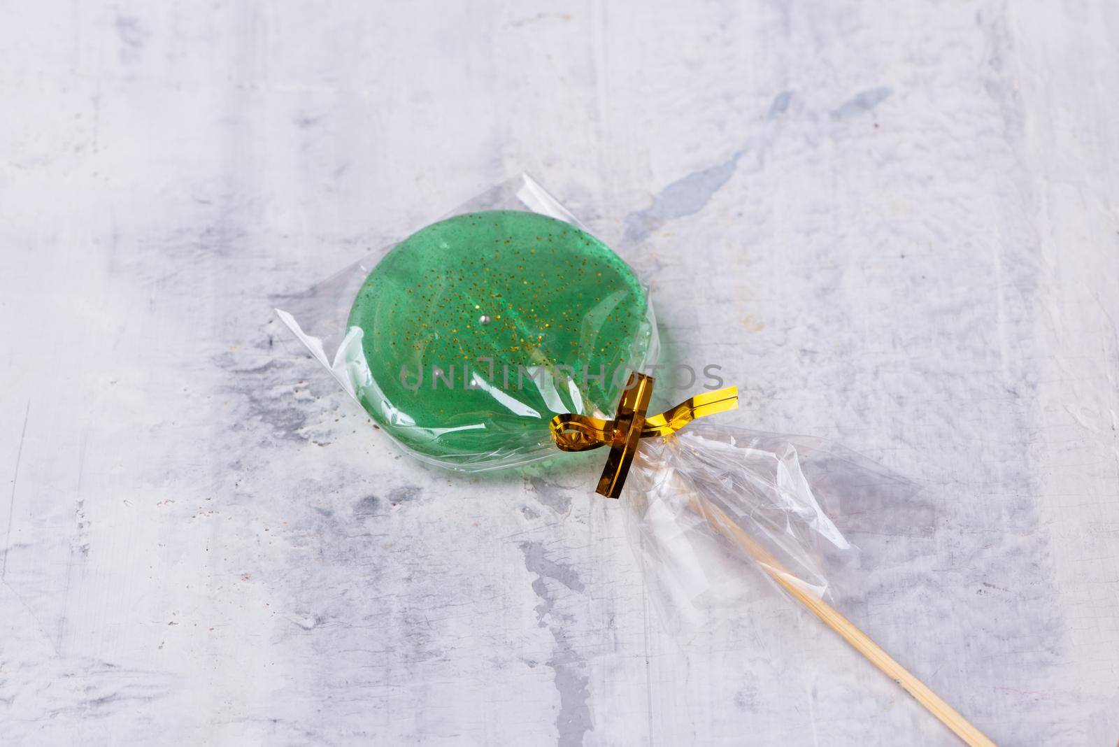 A green lollipop on a textured background