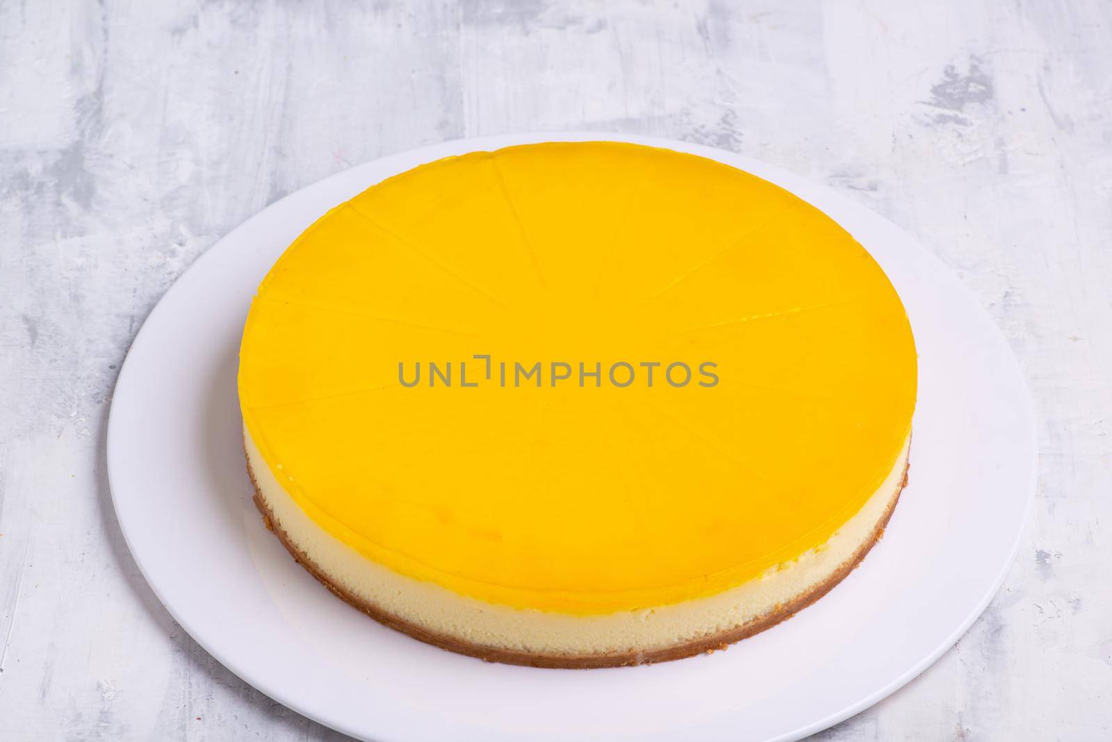 Closeup shot of tasty lemon cheesecake on a white round platted by A_Karim