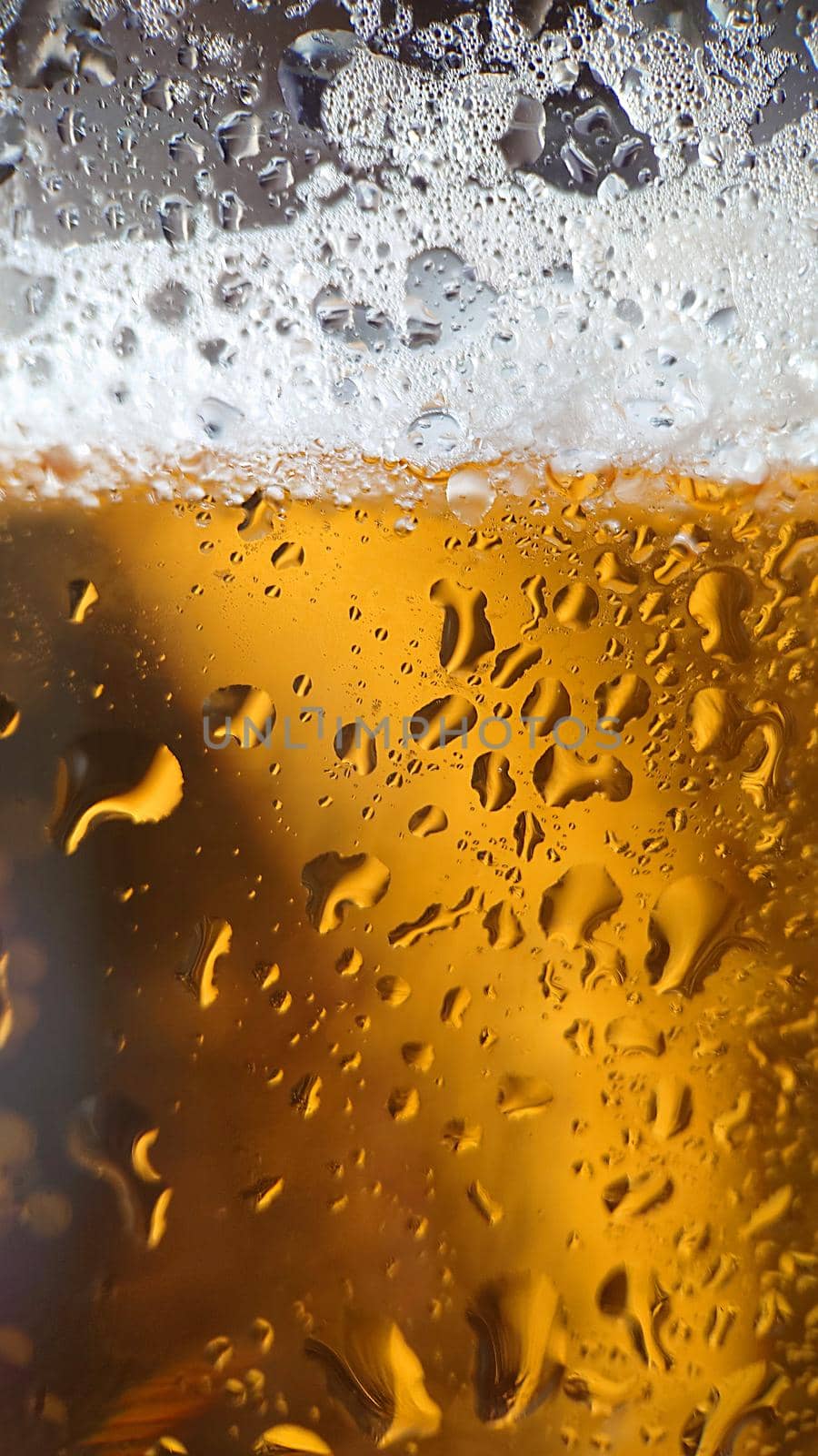Golden beer with bubbles and foam in a glass.Texture or background. Macro