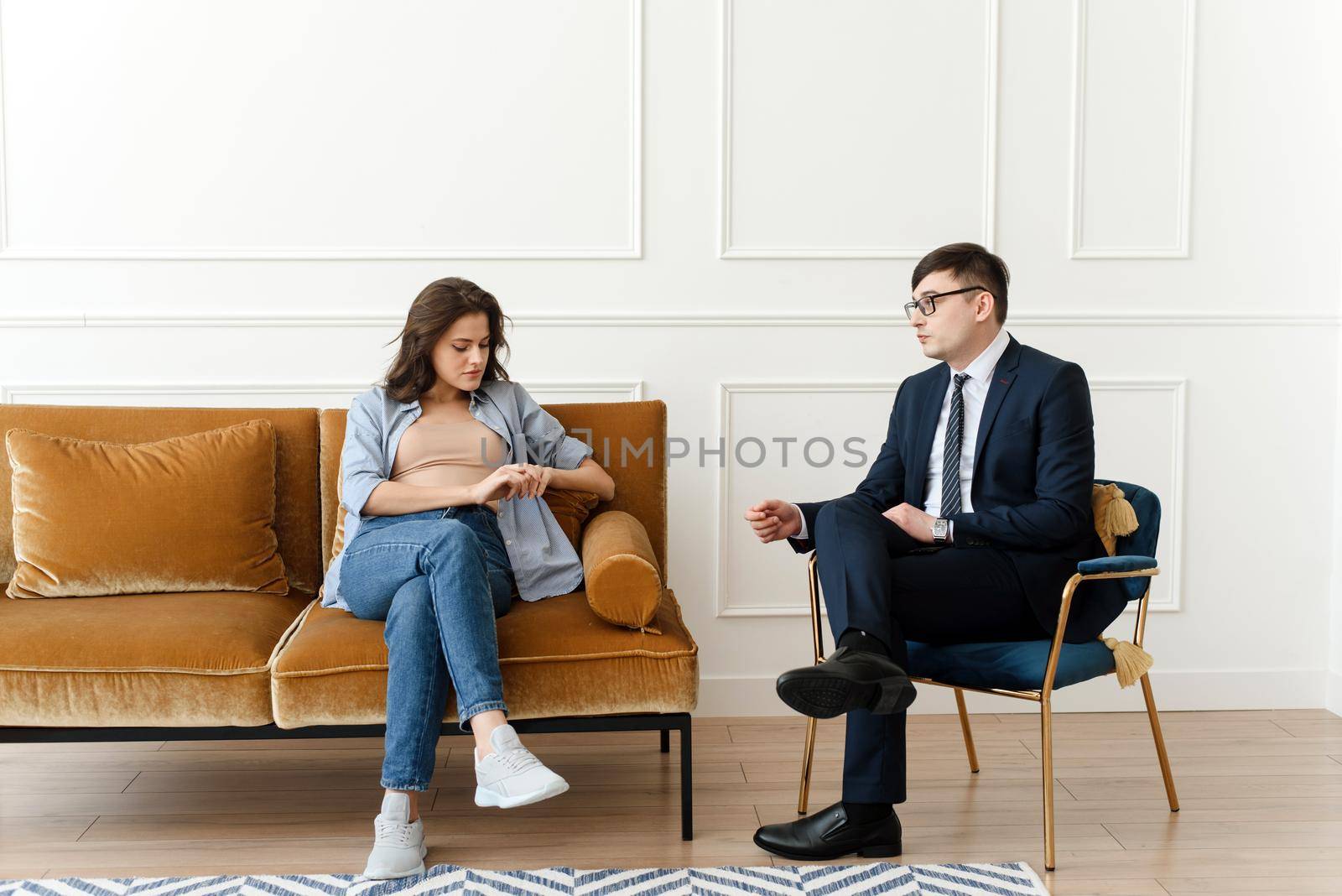 Woman patient with male psychologist consulting and doing psychotherapy with doctor in clinic. Psychiatrist concept.