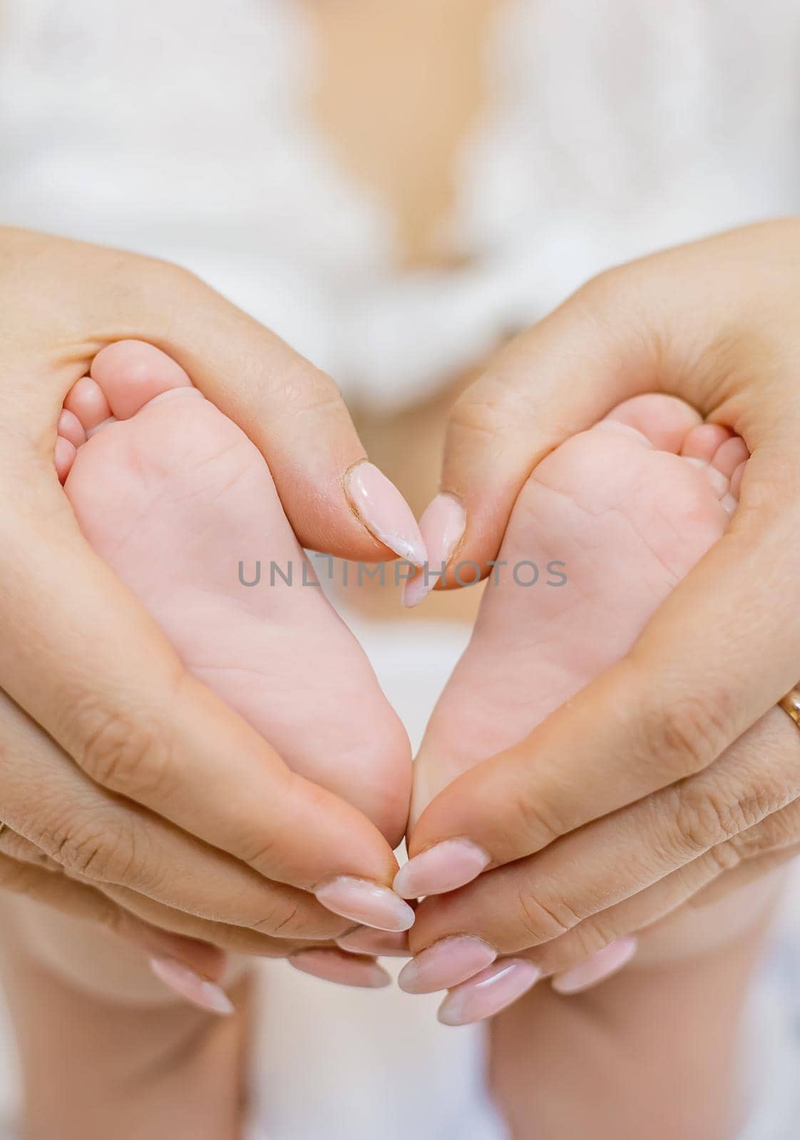 Mom holds the baby's legs. Selective focus. People.