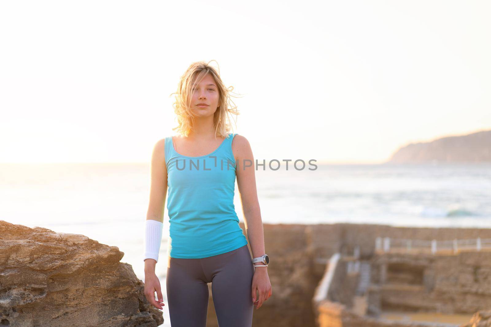 Athletic woman outdoor. Caucasian female sportive woman standing on nature ocean beach. Confident middle age fit woman summer. Dressed active sports wear